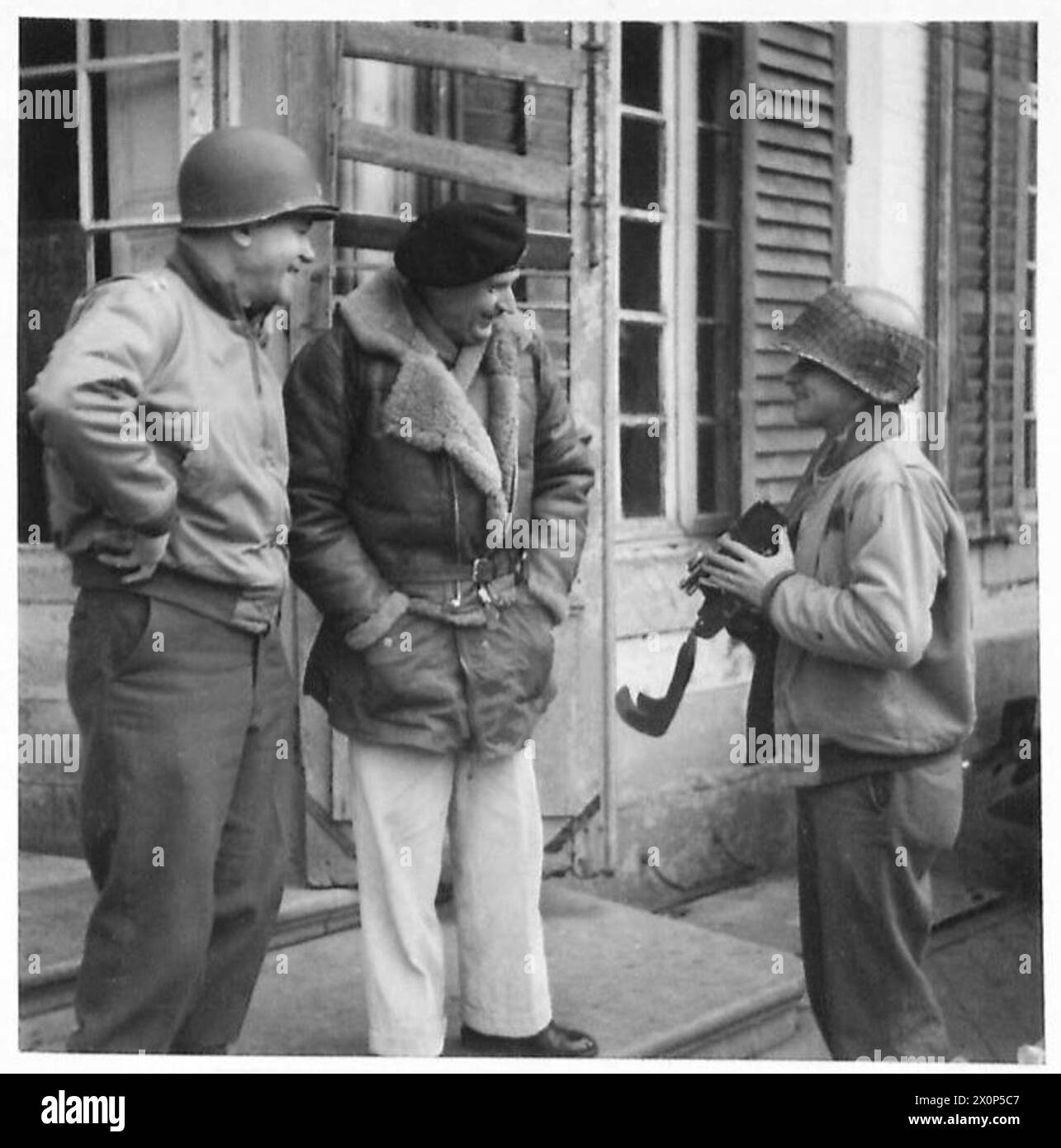 Feldmarschall Montgomery, Oberbefehlshaber der britischen Armee, befragt einen amerikanischen Soldaten über den Einsatz seiner Kamera bei einem Treffen mit US-Truppen. Stockfoto
