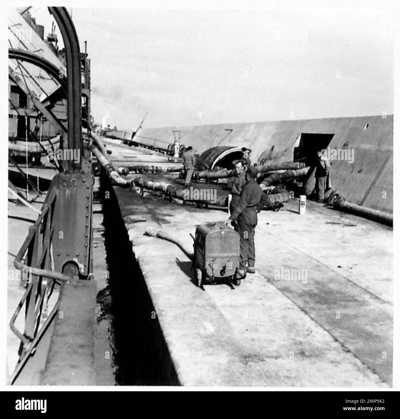 In einem Erdöllager in Nordafrika wird ein Tankfahrzeug für den Pumpbetrieb vorbereitet und angeschlossen. Fotografisches negativ der britischen Armee. Stockfoto
