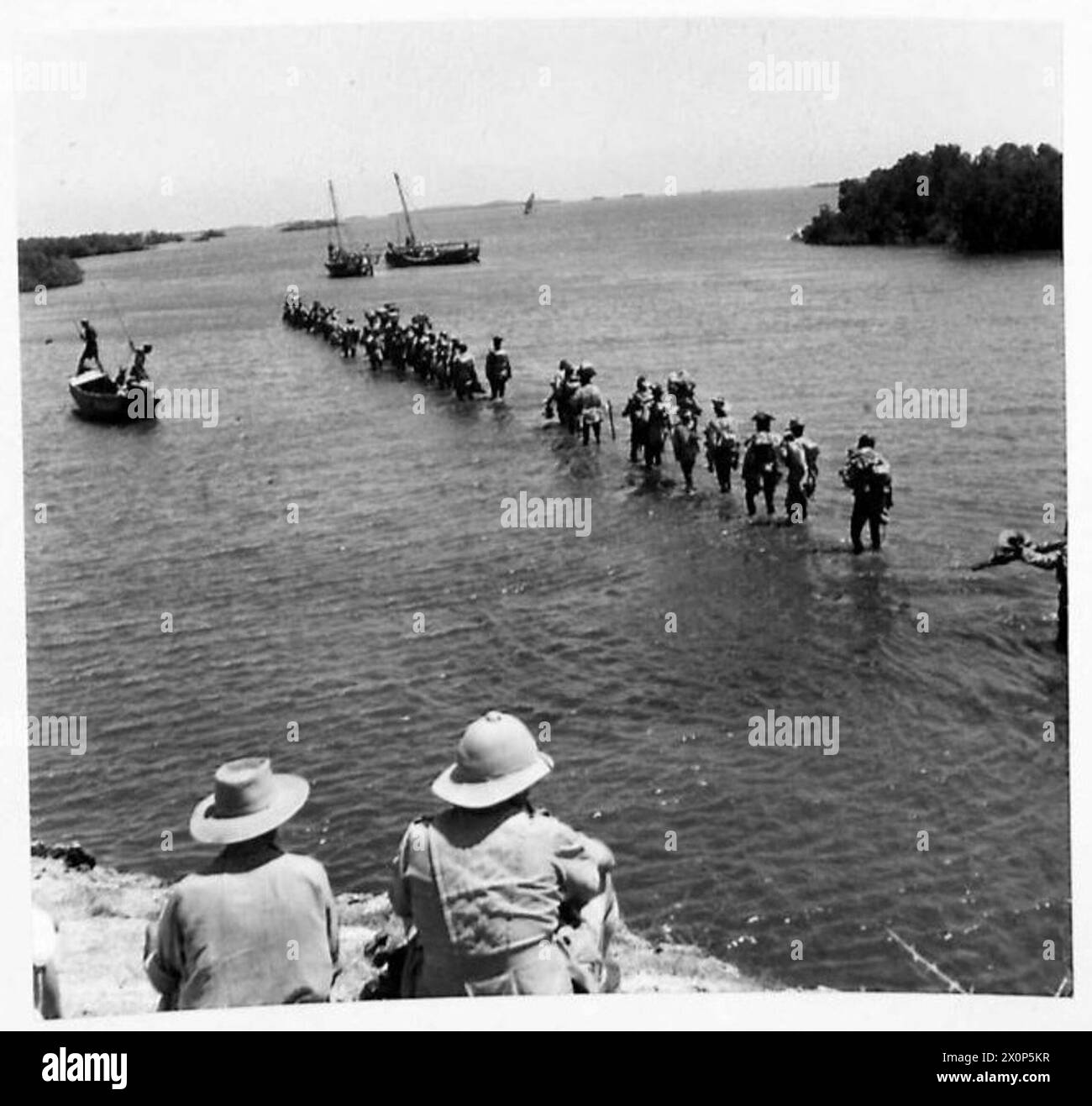 Eine Kompanie der Royal West African Frontier Force waten zu einer Dhow, nachdem sie erfolgreich in das italienische Somaliland entlang der kenianisch-italienischen Grenze nach Somaliland geflogen ist. Stockfoto