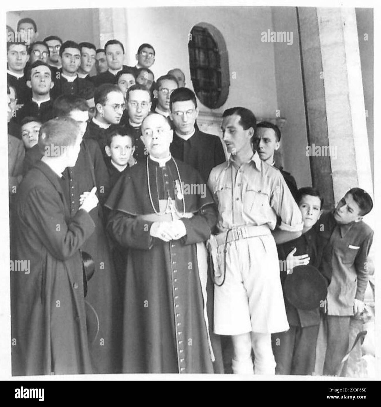 ERSTE BILDER DES KÖNIGS VON ITALIEN - Erzbischof Francesco Petronelli mit seiner Dekoration und Lieut. Denys Hart von Linden Orchard, GT.Bookham, Surrey, Anführer der „Phantome“. Er führte die erste britische Patrouille, die in die Stadt eindrang, und es war für seine Explosion, dass die Deutschen 250 italienische Geiseln nahmen. Lt.Hart wurde nach der Zeremonie in den Palast der Erzbischöfe eingeladen und mit dem Erzbischof von anderen kirchlichen Würdenträgern umgeben gesehen. Fotografisches negativ, britische Armee Stockfoto