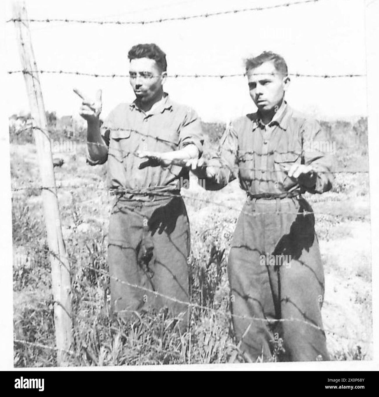 Zwei italienische Gefangene werden von der Fünften Armee im Brückenkopf Anzio festgehalten. Sie berichteten, sie seien politische Gefangene in Deutschland und zum Wehrdienst gezwungen. Fotografisches negativ der britischen Armee. Stockfoto