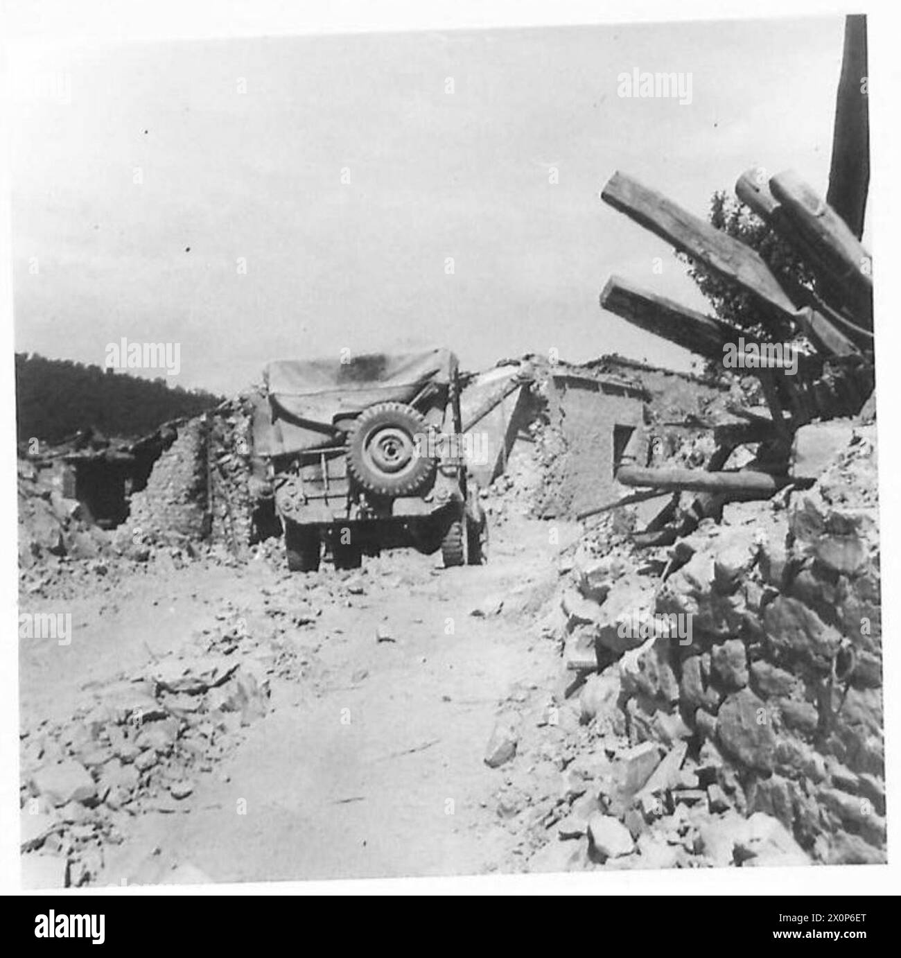 Bulldozer der achten Armee räumen eine neue Straße durch ein Dorf, wo Häuser von deutschen Truppen zerstört wurden, um den Zugang zu blockieren. Stockfoto