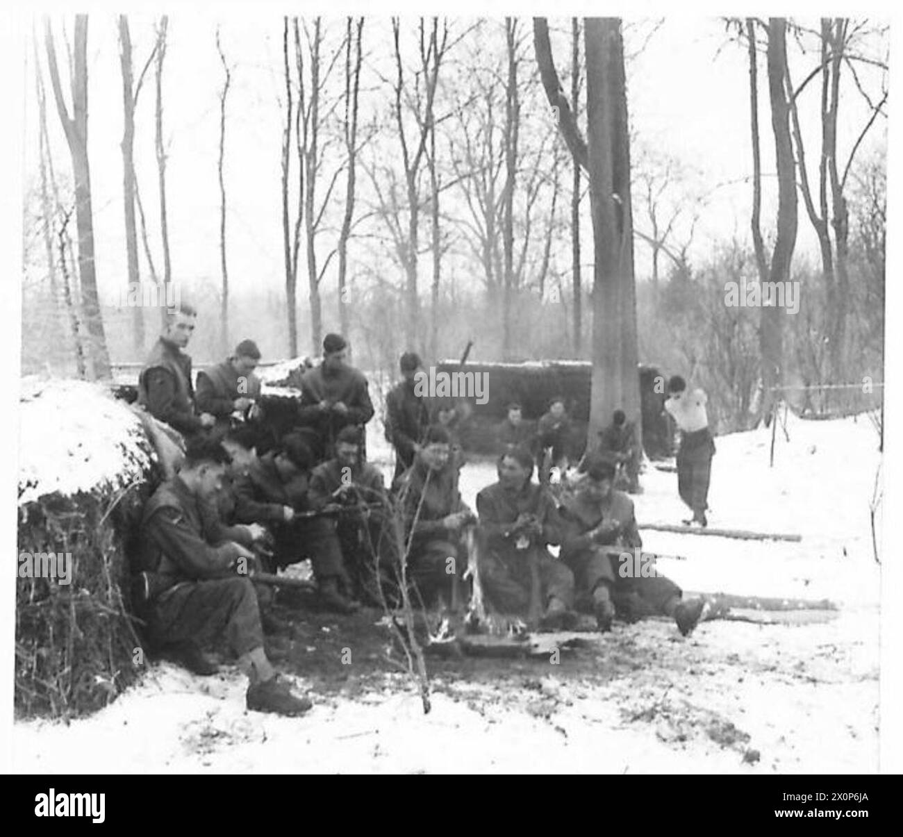 KAMPFPATROUILLENKURS - Soldaten reinigen ihre Arme um das Lagerfeuer. Fotografisches negativ, britische Armee Stockfoto