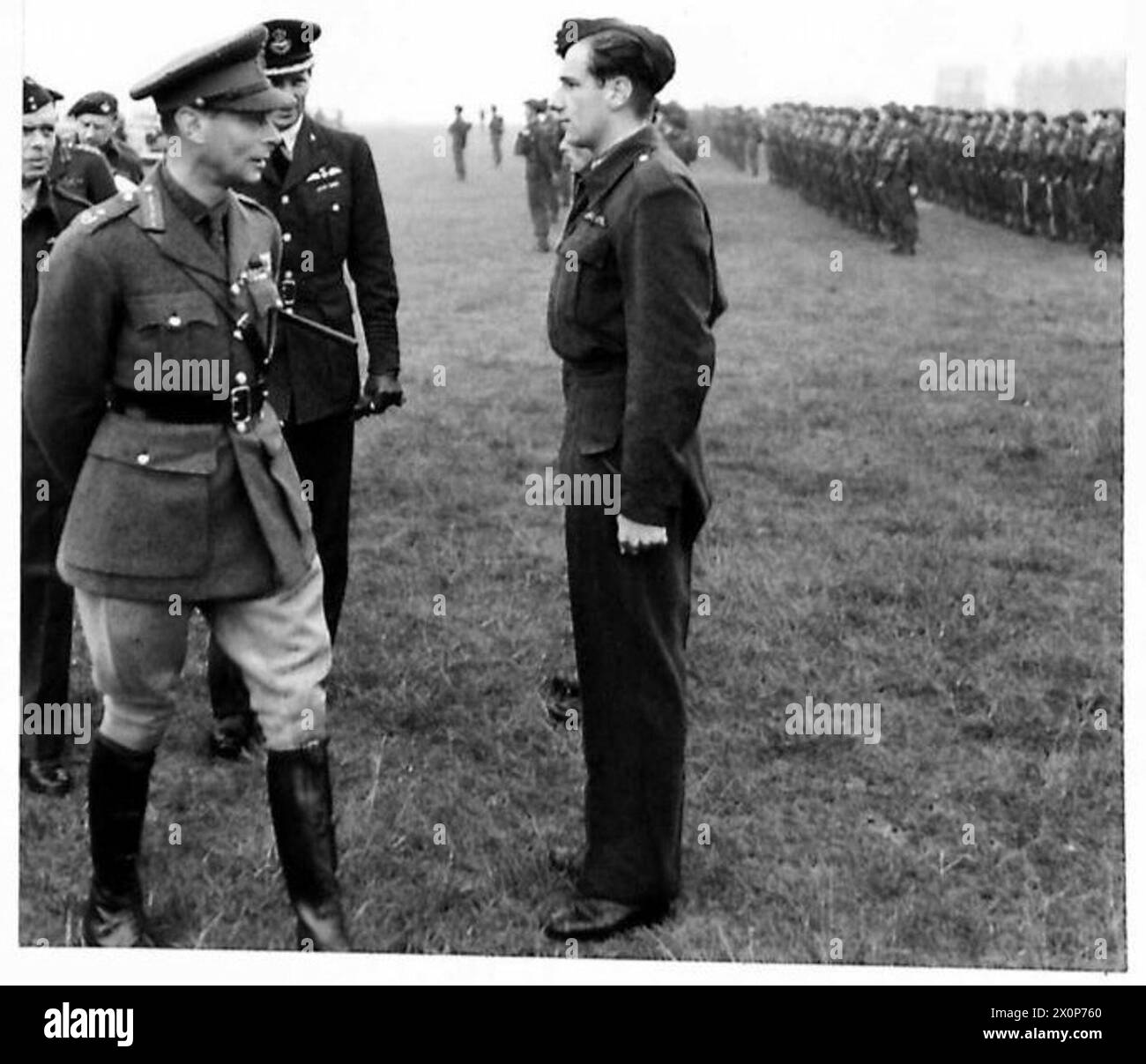 Der König und die Königin inspizieren Luftlandeeinheiten auf einem Flugplatz und beobachten einen Piloten während der Inspektion. Stockfoto