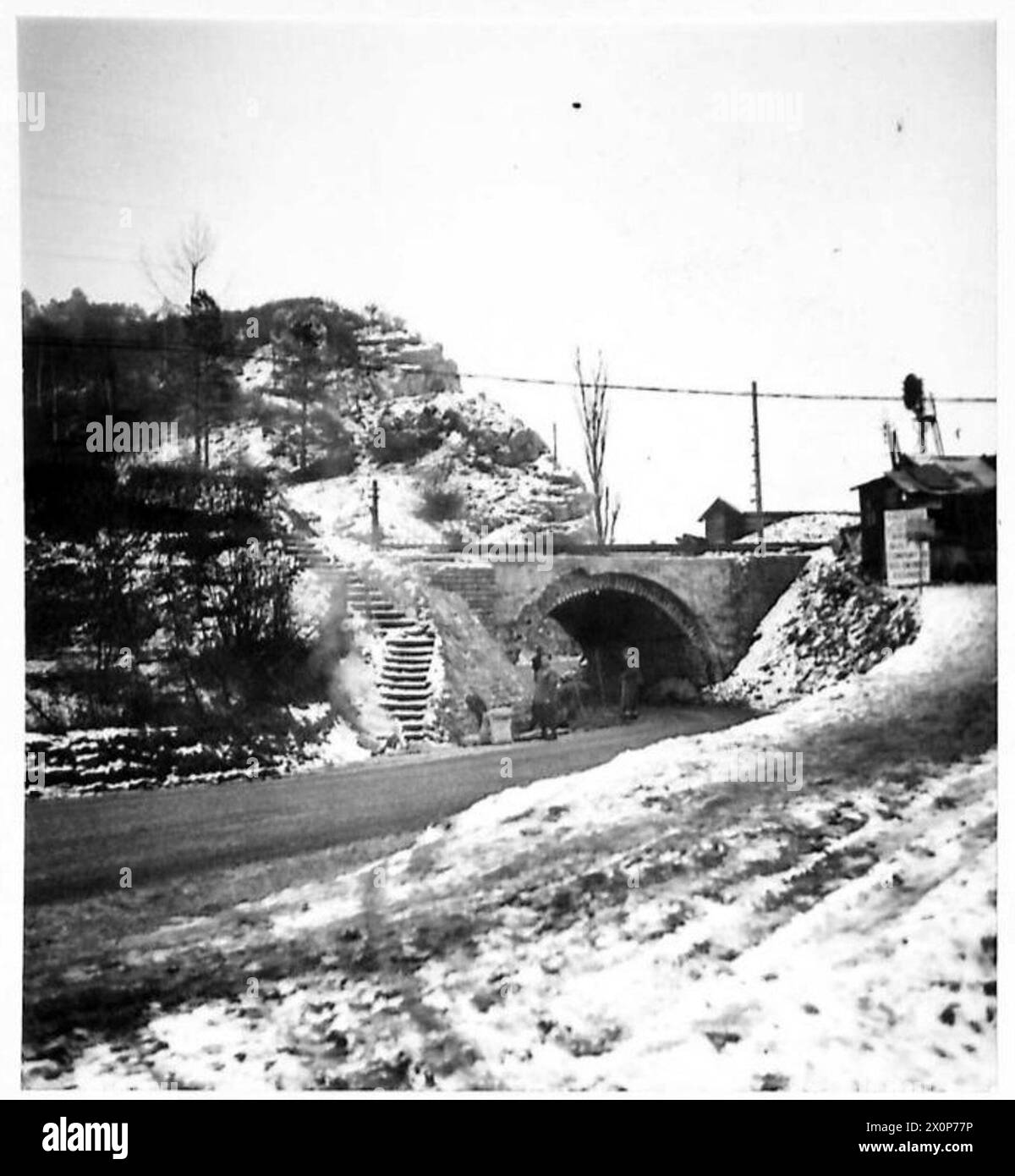 Fotografisches negativ, das Royal Engineers zeigt, die in der Nähe einer niedrigen Brücke um Dinant arbeiten, die Schwierigkeiten für schwere Transporte mit sich bringt, was logistische Herausforderungen für die Truppen veranschaulicht. Stockfoto