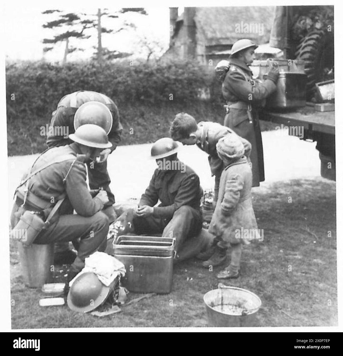 Während einer Anti-Invasion-Übung werden Truppen beobachtet, die eine Mahlzeit zubereiten, während Kinder beobachten und dabei Feldoperationen und Truppenübungen der britischen Armee dokumentieren. Fotografisches negativ der britischen Armee. Stockfoto
