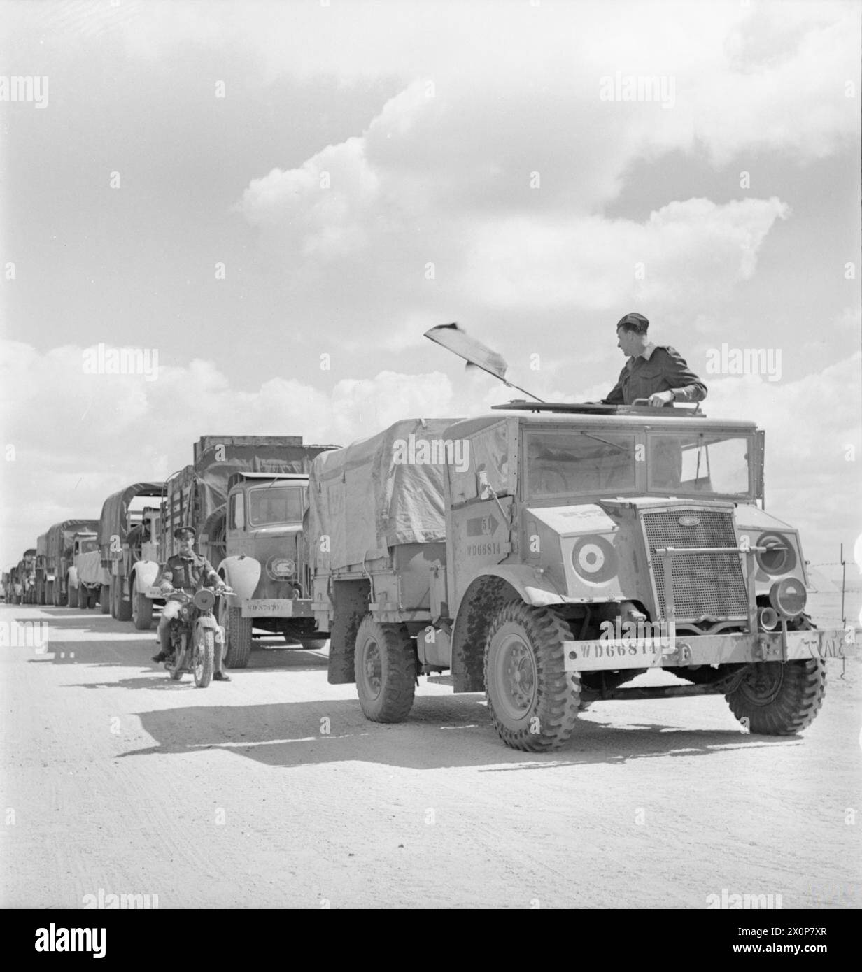 Der Leiter eines RAF-Transportkonvois signalisiert den Fahrzeugen, während der Operationen nach Tunesien (1939-1943) von ihrem Stützpunkt in Libyen abzufahren. Stockfoto