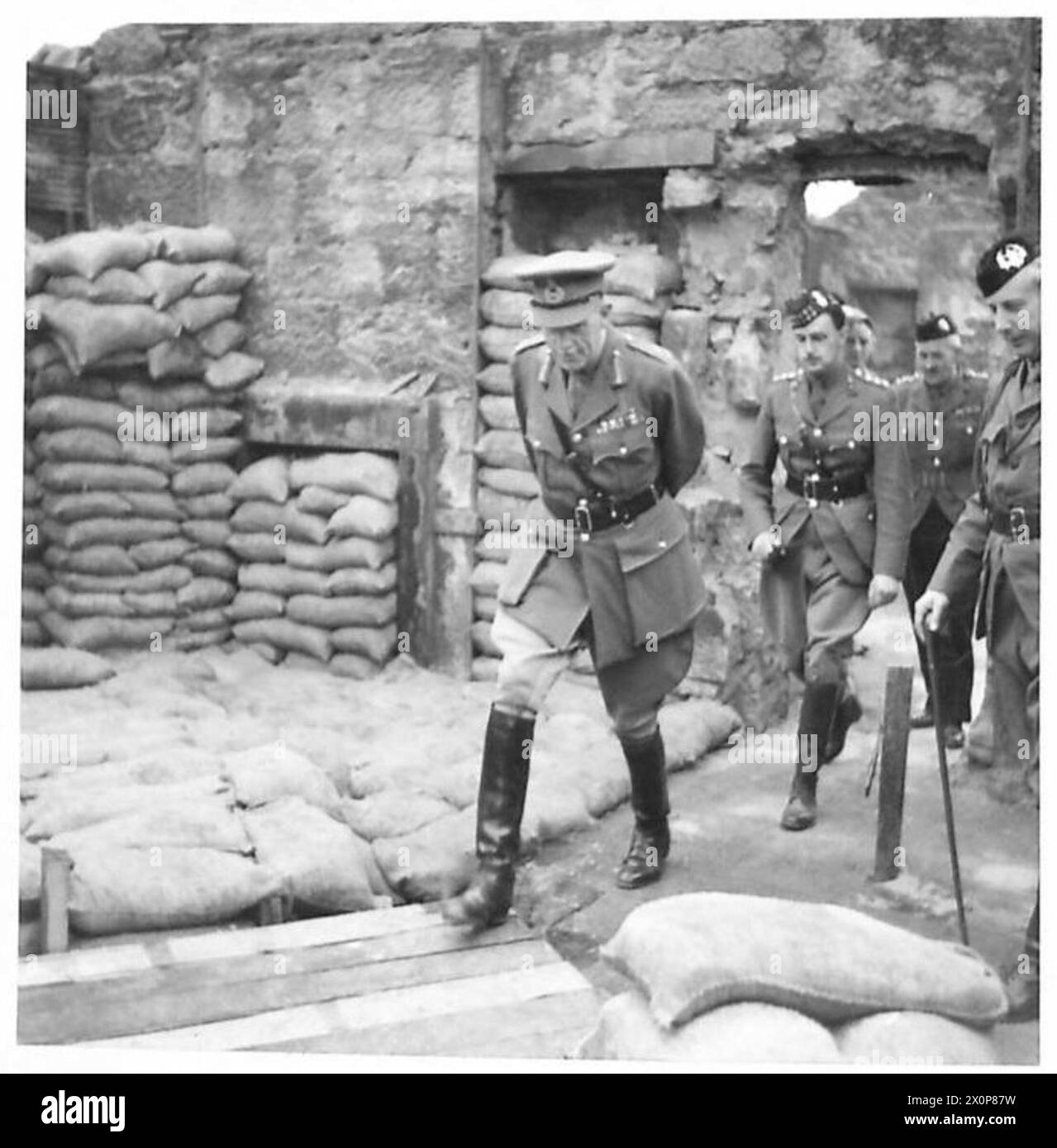 Major General Johnson inspiziert die Glasgow Home Guard Fighting School und überprüft Gebäude, die mit Sprengfallen ausgestattet sind, für Straßenkämpfe. Ein fotografisches negativ dokumentiert den Besuch. Stockfoto