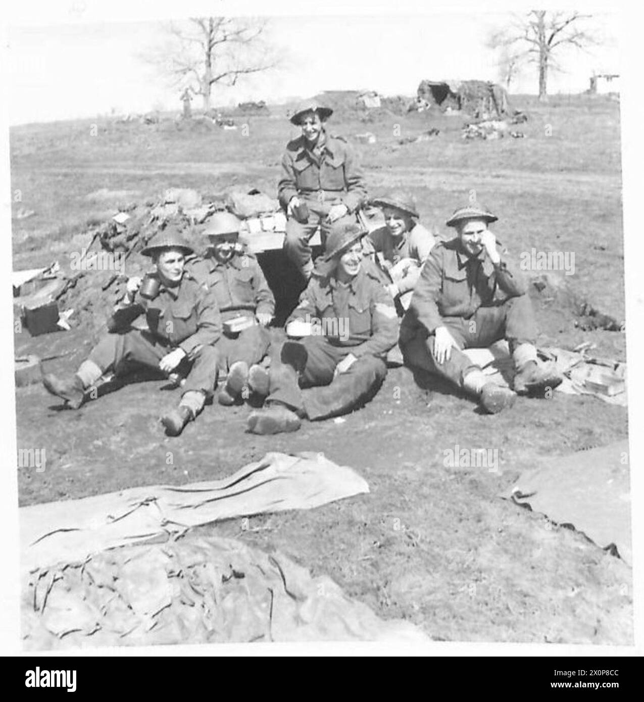 FÜNFTE ARMEE : ANZIO BRIDGEHEADTHE IRISCHES BATAILLON FEIERT ST.PATRICK's TAG IN DER LINIE - die Männer genießen ihre Tassen Rum. Sie sind: FUS. Moore of Cowley Hill Lane, St. Helena, Lancs., Fos. O'Shea von South Douglas Road, Cork, Eire Sgt. Gallagher von Brandywell Avenue, Londonderry 2/Lieut. Scarrall von „Lorbeeren“ Neston Cheshire FUS. Hogg aus Ballylucan, Co.Down FUS. J. Burns of Phillips Street, Londonderry fotografisches negativ, British Army Stockfoto