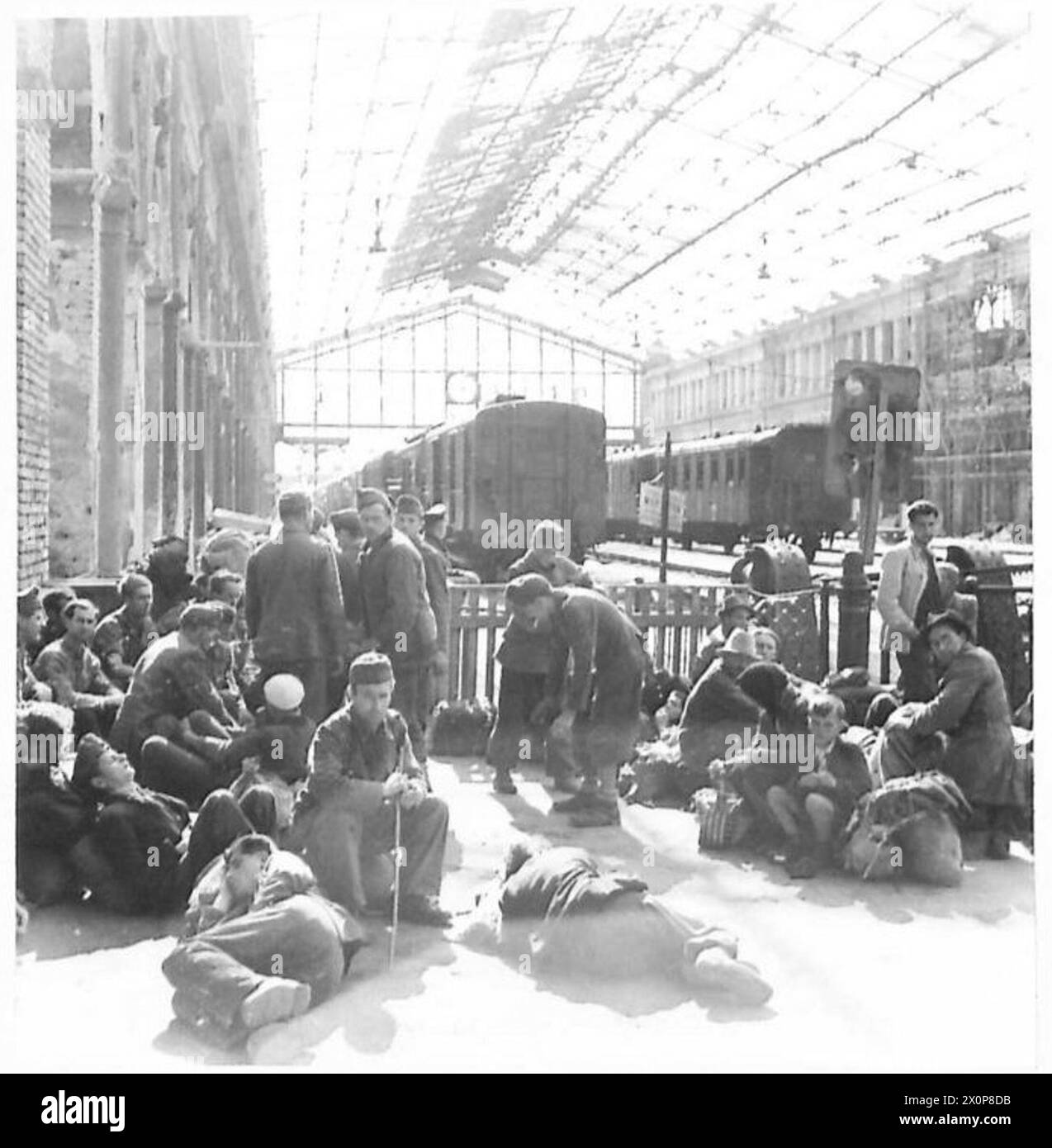 Flüchtlinge warten am Wiener Hauptbahnhof auf einen Zug, der die Vertreibung und die Transportbedingungen der Nachkriegszeit veranschaulicht. Stockfoto