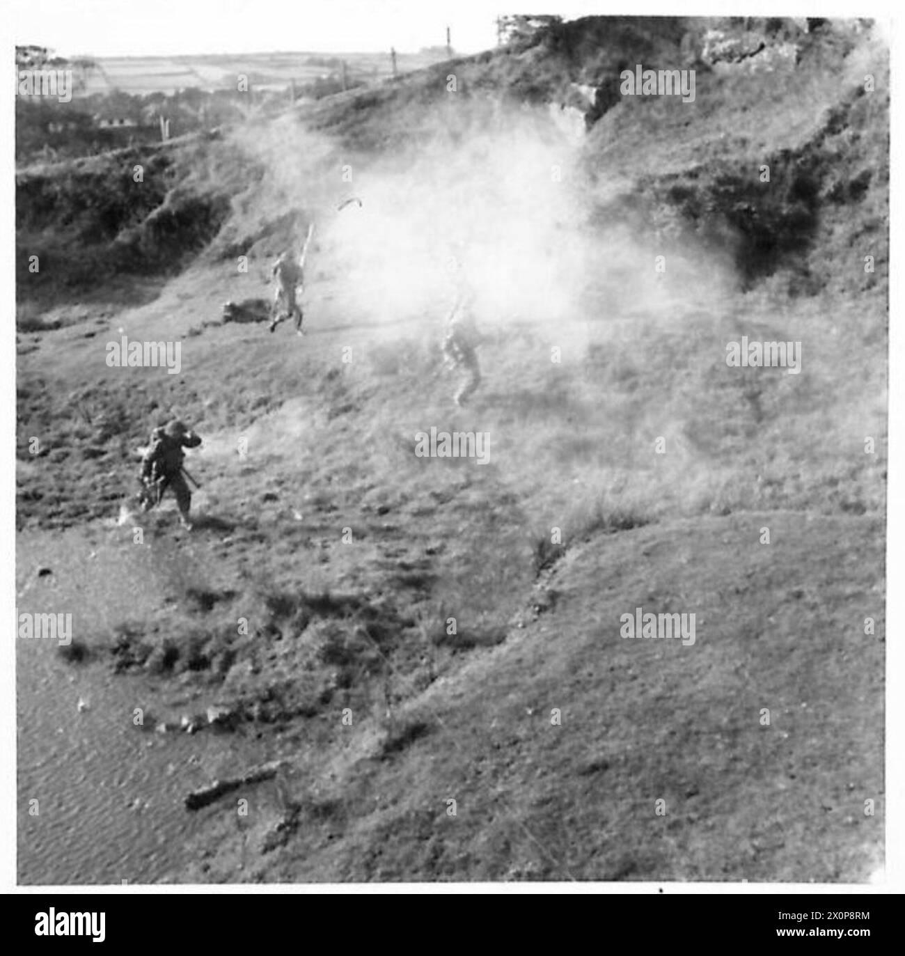Infanterie-Truppen dringen durch sumpfiges Gelände unter simuliertem Granatfeuer während der Trainingsübungen der British Army vor. Stockfoto