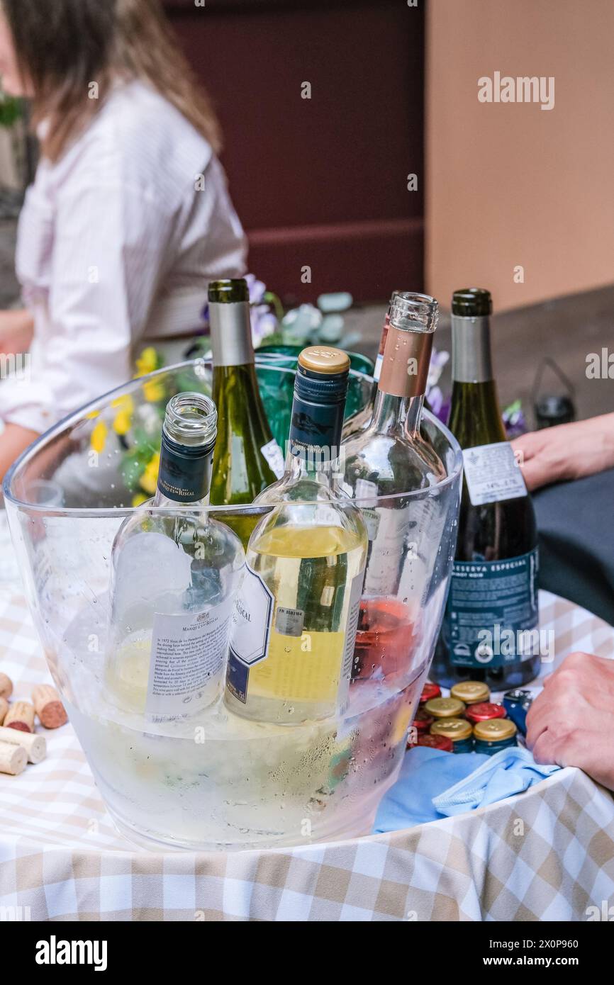 Offene Flaschen mit weiß- und Rotwein verschiedener Marken zur Verkostung gekühlt im Eiskübel: RIGA, LETTLAND - 15. JUNI 2023 Stockfoto