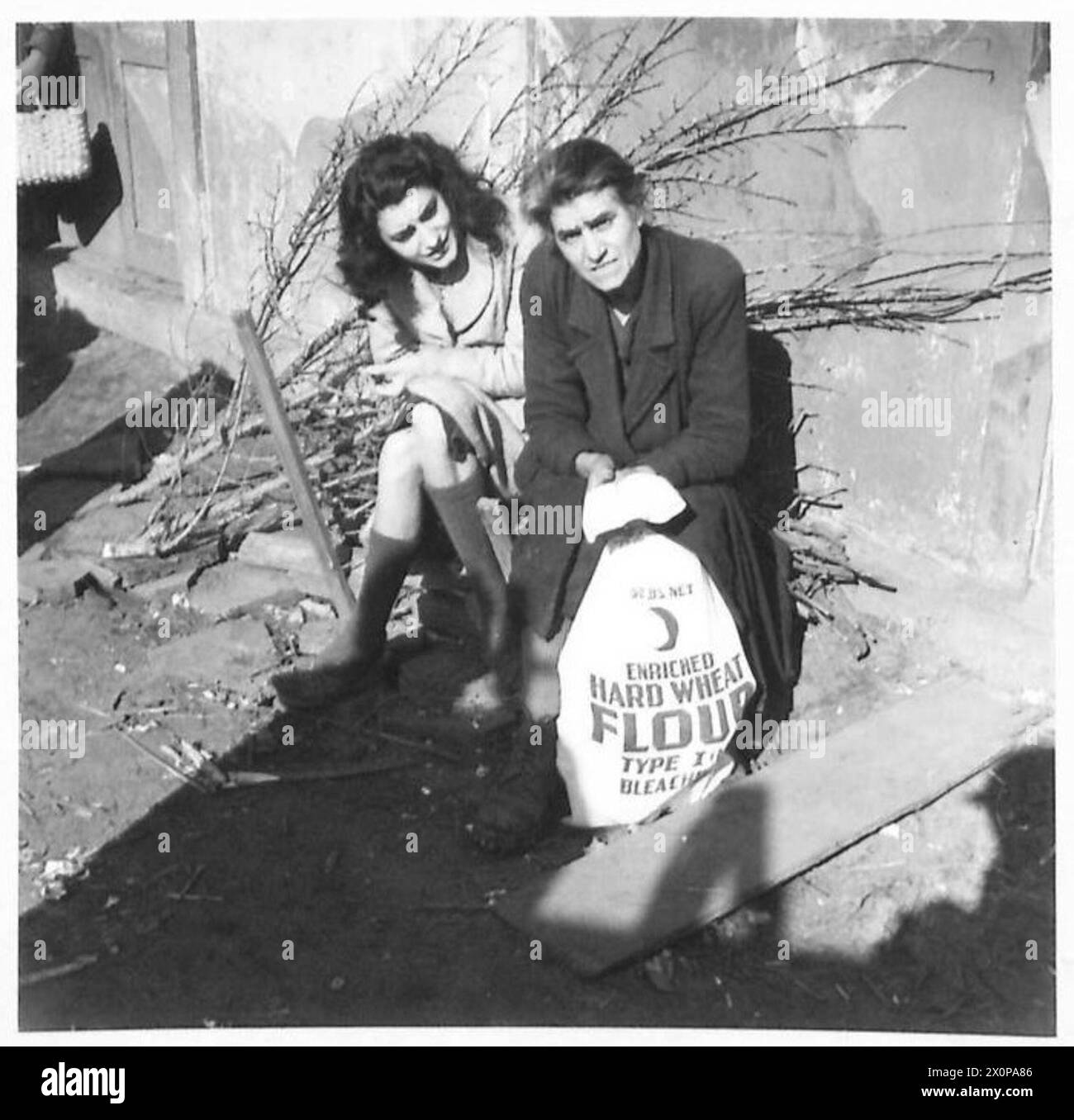 Eine alte Frau und ihre Tochter erhalten Brotrationen von A.M.G. am Anzio Brückenkopf. Fotografisches negativ, britische Armee. Stockfoto