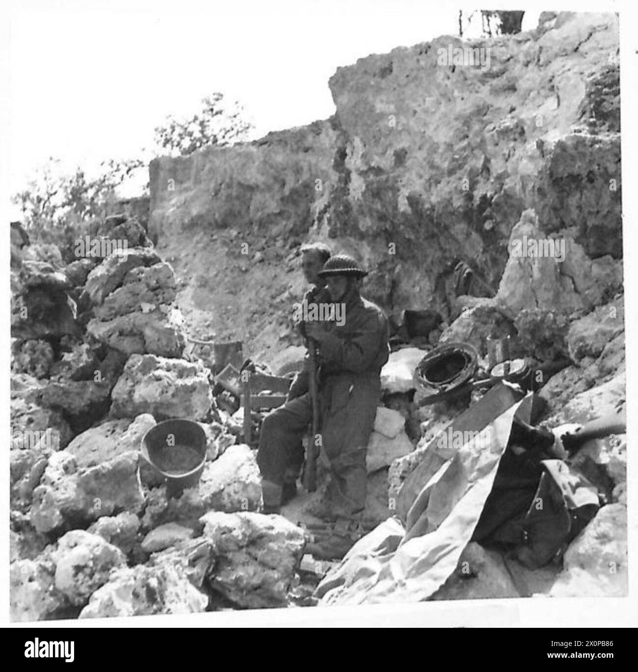 NACHWIRKUNGEN DER SCHLACHT UM CASSINO – während einer Einsamkeit in den Kampfmännern von „D“ Coy. 1 Royal Irish Fusiliers, eine Forward Company, untersucht einige ihrer Trophäen. Von links nach rechts FUS. Johns of Gamelyn Place, Aboramen, S. Wales FUS. Pottinger von 54 Rector Road, Liverpool (M.R. Blatt 16o: 81296). Fotografisches negativ, britische Armee Stockfoto