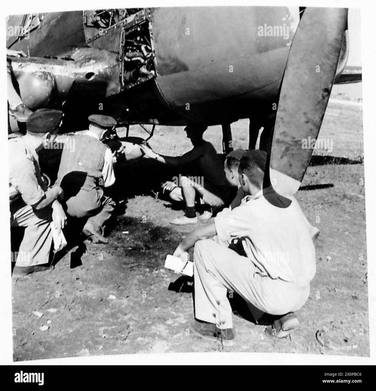 ACHTE ARMEE: INFANTERIE TRIFFT AUF DIE FLIEGENDE ARTILLERIE - ein weiteres Geschwader bombardiert. Der Offizier des Flügelingenieurs zeigt, wie die 250-Pfund-Bomben unter das Flugzeug passen. Die Handwerker arbeiten an der Einstellung von Sicherungen. Unter jedem Flügel befinden sich drei 40-Pfund-Bomben. Die Armeeoffiziere beobachten. Fotografisches negativ, britische Armee Stockfoto