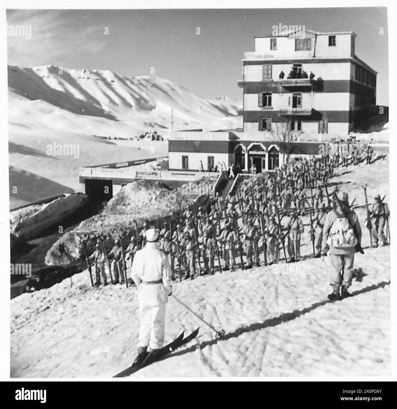 Die Skitruppen der Skischule ziehen während des Trainings vor dem Hauptsitz des Hotels auf eine Parade. Stockfoto