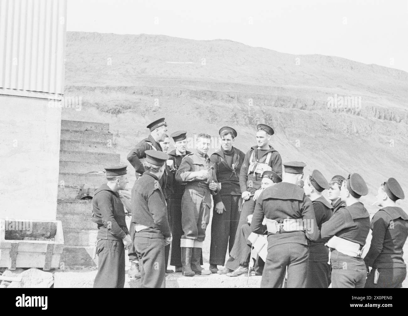 Seeleute auf der HMS Suffolk, die im Mai 1941 an einem abgelegenen Aussichtsposten vor Nordwesten Islands stationiert waren, beobachten feindliche Schiffsbewegungen. Vier Seeleute verwalten den Posten, 40 Meilen von der nächsten Siedlung entfernt, abgeschnitten von Bergen. Ein ehemaliger Kranfahrer teilt seine Erfahrungen mit Kollegen auf dem Kreuzer. Stockfoto