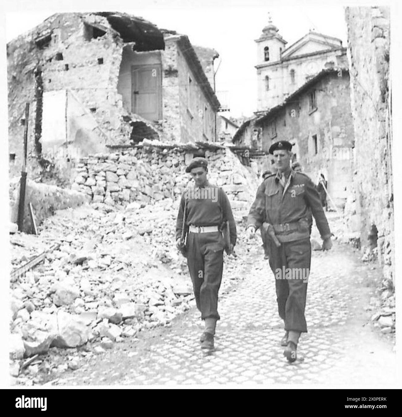 Der Corps Commander und Major F.G. Mann, Kommandant der Scots Guards Company, laufen durch eine ruinierte Frontstadt in Italien, dokumentiert in einem Fotonegativ der britischen Armee. Stockfoto