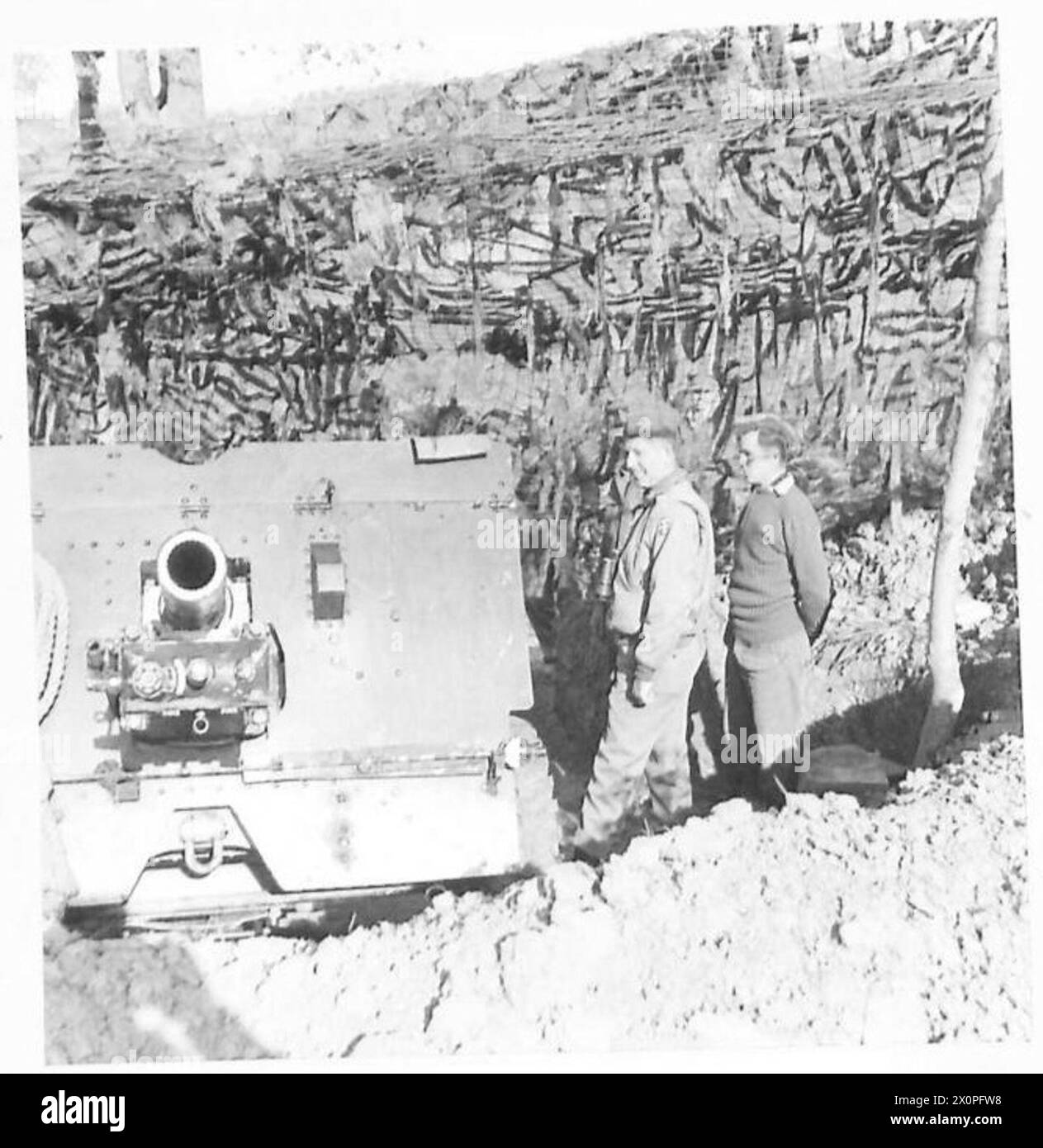 General Devers inspiziert eine 25-Pfünder-Kanone an der Ostitalienischen Front, die vom Major Temple of Cheshire erklärt wurde; die Kanonen werden von britischen Mitarbeitern zur Unterstützung indischer Truppen betrieben. Stockfoto