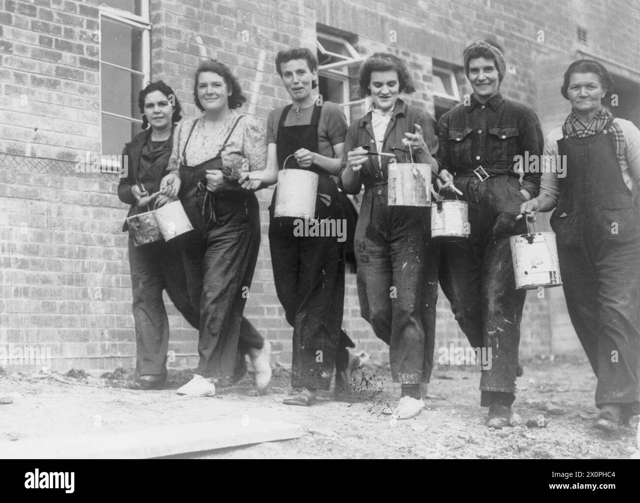Sechs Malerinnen arbeiteten auf einer Baustelle des Versorgungsministeriums, die 1939–1945 Häuser für Rüstungsarbeiter bauten. Stockfoto