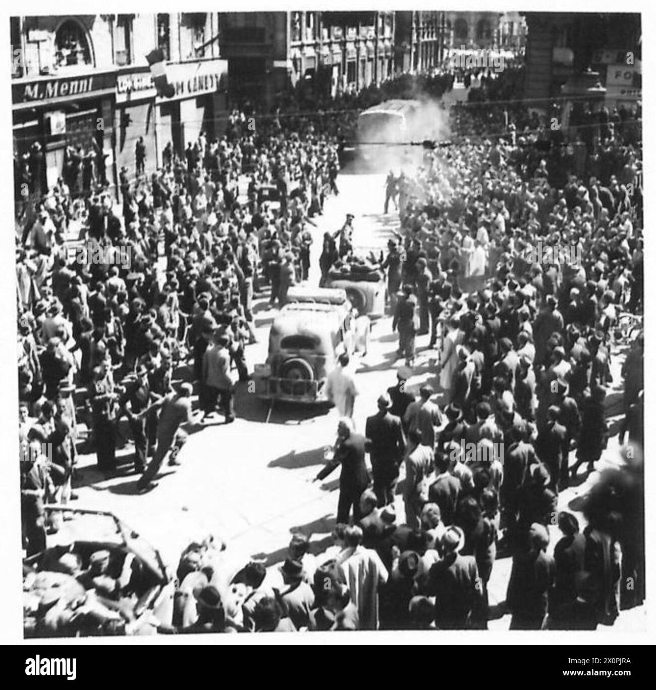 In Mailand umzingelte Soldaten der SS ergeben sich, während die lokale Bevölkerung reagiert, während Lastwagen sich durch die Menge bewegen müssen. Stockfoto