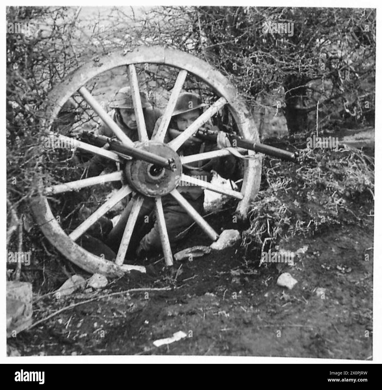 AUSBILDUNG IN IRLAND - diese Truppen finden ein Versteck hinter einem alten Wagenrad. Fotografisches negativ, britische Armee Stockfoto