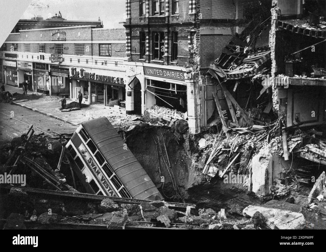 THE LONDON BLITZ 1940 - 1941 - Foto aufgenommen am 15.10.40. Um 20.02 Uhr am 14. Oktober 1940 fiel eine 1400 kg schwere Halbpanzerbombe auf der Balham U-Bahn Station ab, die den hier gezeigten massiven Krater verursachte. Die Bombe explodierte 32 Fuß unter der Erde über dem Durchgang, der die beiden Bahnsteige verband. Ein Bus der Linie 88 fuhr in der Verdunkelungszone direkt in den Krater. Etwa 600 Menschen waren in der Station untergebracht, als die Bombe explodierte. Wasser-, Gas- und Abwasserleitungen waren alle kaputt und viele Menschen ertranken als der Bahnhof überschwemmte. 68 Menschen wurden getötet Stockfoto