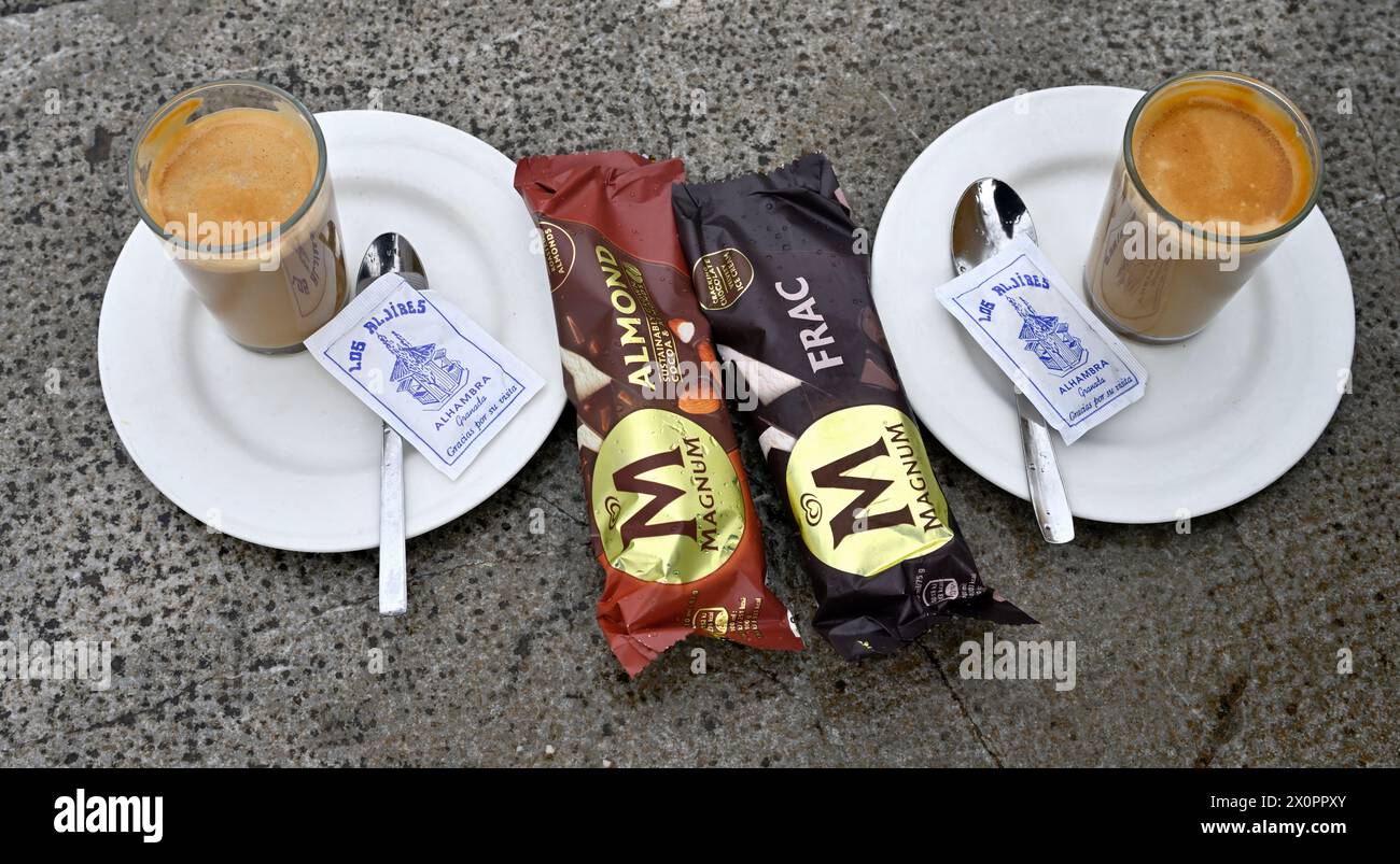 Wo Magnum Eisriegel, zwei Gläser Kaffee auf Tellern mit Löffeln, Päckchen Zucker, Stockfoto