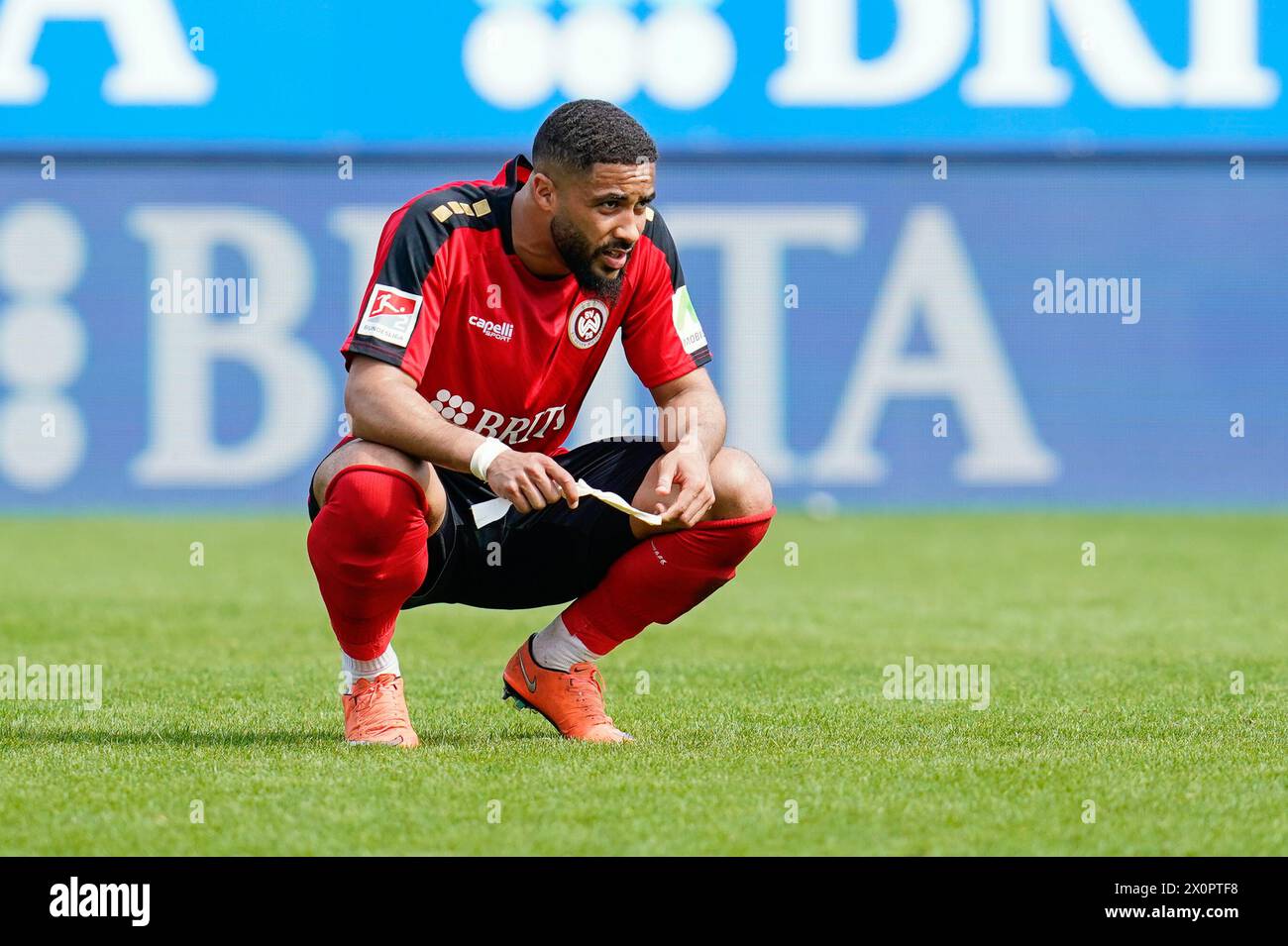 Wiesbaden, Deutschland. April 2024. Fußball: Bundesliga 2, SV Wehen Wiesbaden - Fortuna Düsseldorf, Spieltag 29, BRITA-Arena. Wiesbadener Keanan Bennetts hockt am Ende des Spiels auf dem Platz. Hinweis: Uwe Anspach/dpa – WICHTIGER HINWEIS: gemäß den Vorschriften der DFL Deutscher Fußball-Liga und des DFB Deutscher Fußball-Bundes ist es verboten, im Stadion und/oder des Spiels aufgenommene Fotografien in Form von sequenziellen Bildern und/oder videoähnlichen Fotoserien zu verwenden oder zu nutzen./dpa/Alamy Live News Stockfoto