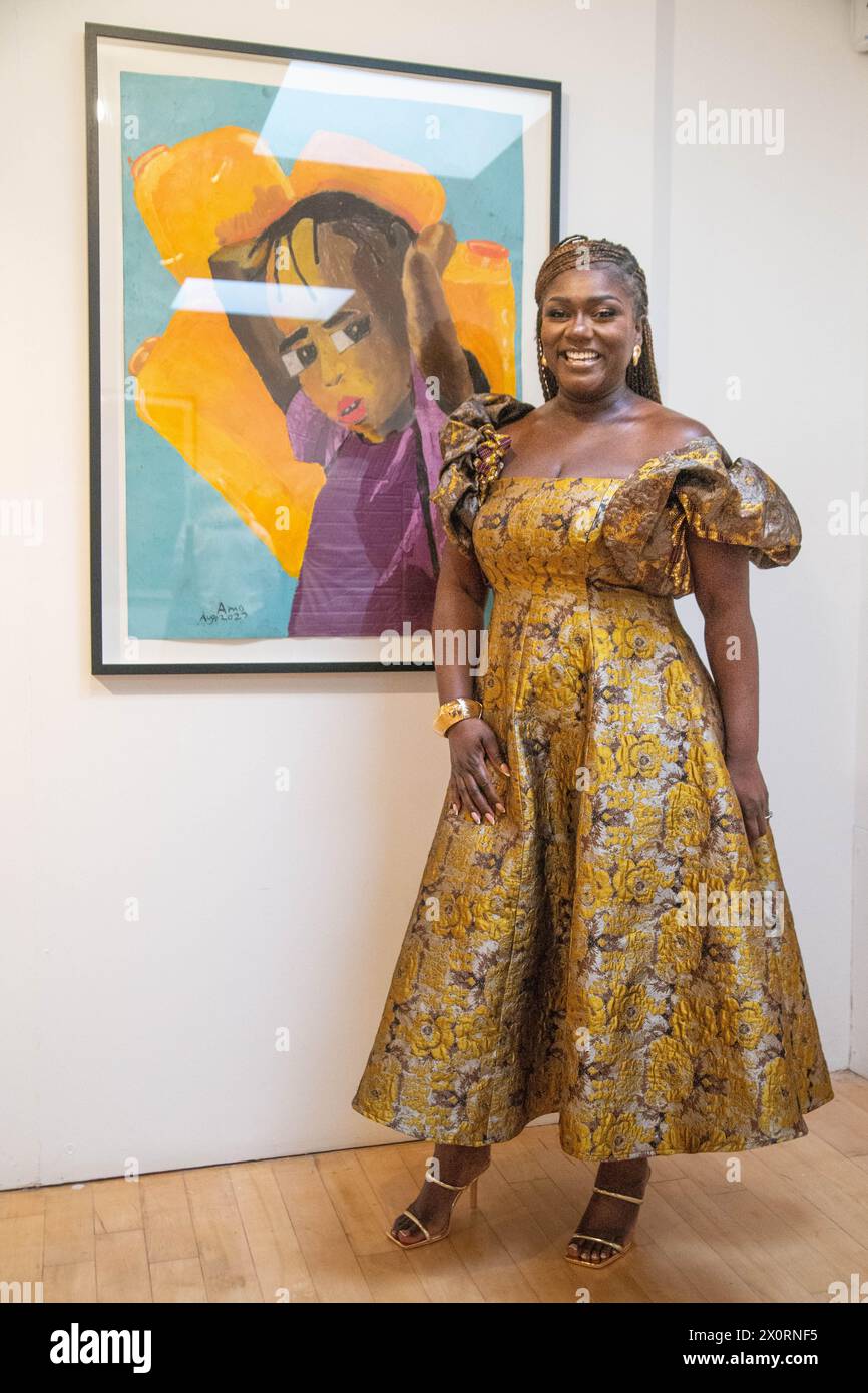 London, Großbritannien. April 2024. Dentaa Amoateng MBE posiert mit Portrait und GUBA bei der Autism, Awareness and Acceptance Exhibition im Tabernacle, Notting Hill, wo die Arbeit der elfjährigen Ama Antiwaa Amponsah gezeigt wird, einer nonverbalen Künstlerin, die tiefgreifende Einblicke und Zeichenkunst demonstriert. Quelle: Peter Hogan/Alamy Live News Stockfoto