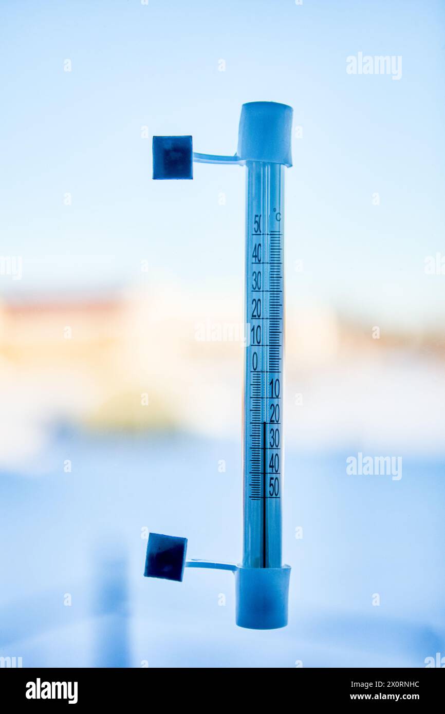 20 Grad unter Null Celsius auf einem Außenthermometer, das auf der Straßenseite mit Glasscheiben verklebt ist. Stockfoto