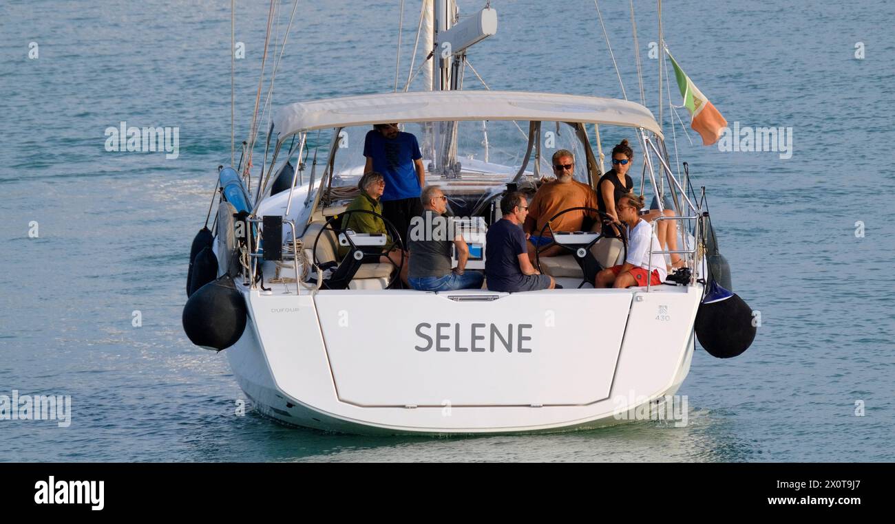 Italien, Sizilien, Mittelmeer, Marina di Ragusa (Provinz Ragusa); 13. April 2024, Menschen auf einem Segelboot im Hafen - EDITORIAL Stockfoto