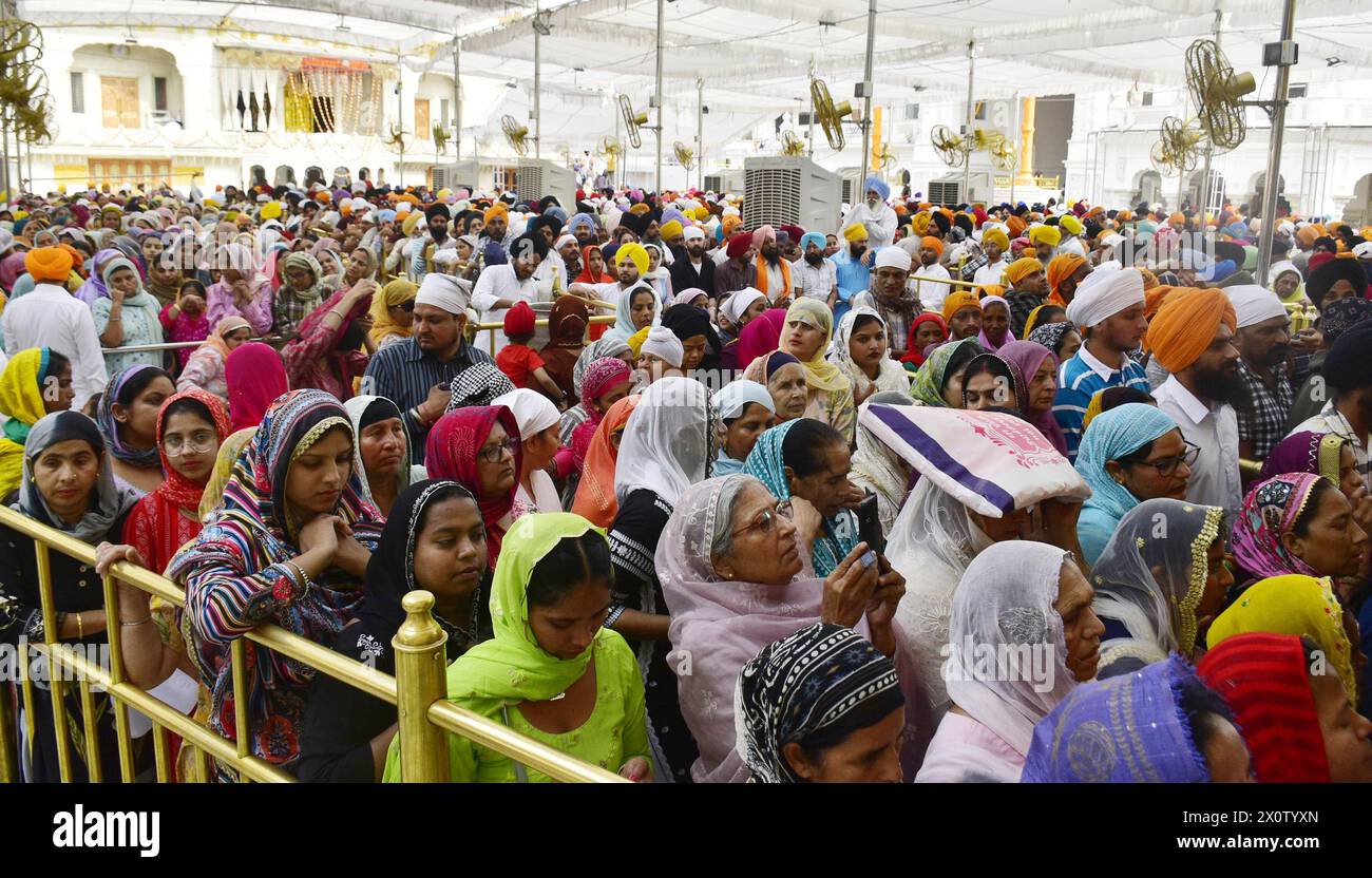 AMRITSAR, INDIEN – 13. APRIL: Gläubige, die sich anlässlich des Baisakhi-Festivals am 13. April 2024 im Goldenen Tempel in Amritsar, Indien, verbeugen. Baisakhi oder Vaisakhi, ein beliebtes Frühlingsfest, das den ersten Tag des Monats Vaisakh markiert, wird mit viel Enthusiasmus unter den Hindu-, Sikh- und buddhistischen Gemeinschaften gefeiert. Es ist der Beginn des Punjabi und Sikh Neujahrs, das in ganz Indien gefeiert wird, insbesondere in Punjab und Nordindien. Baisakhi wird am 13. April dieses Jahres beobachtet, was den Beginn der Erntesaison in Punjab einläutet. Es fällt am ersten Tag des Hindu-Sonnenjahres. ( Stockfoto