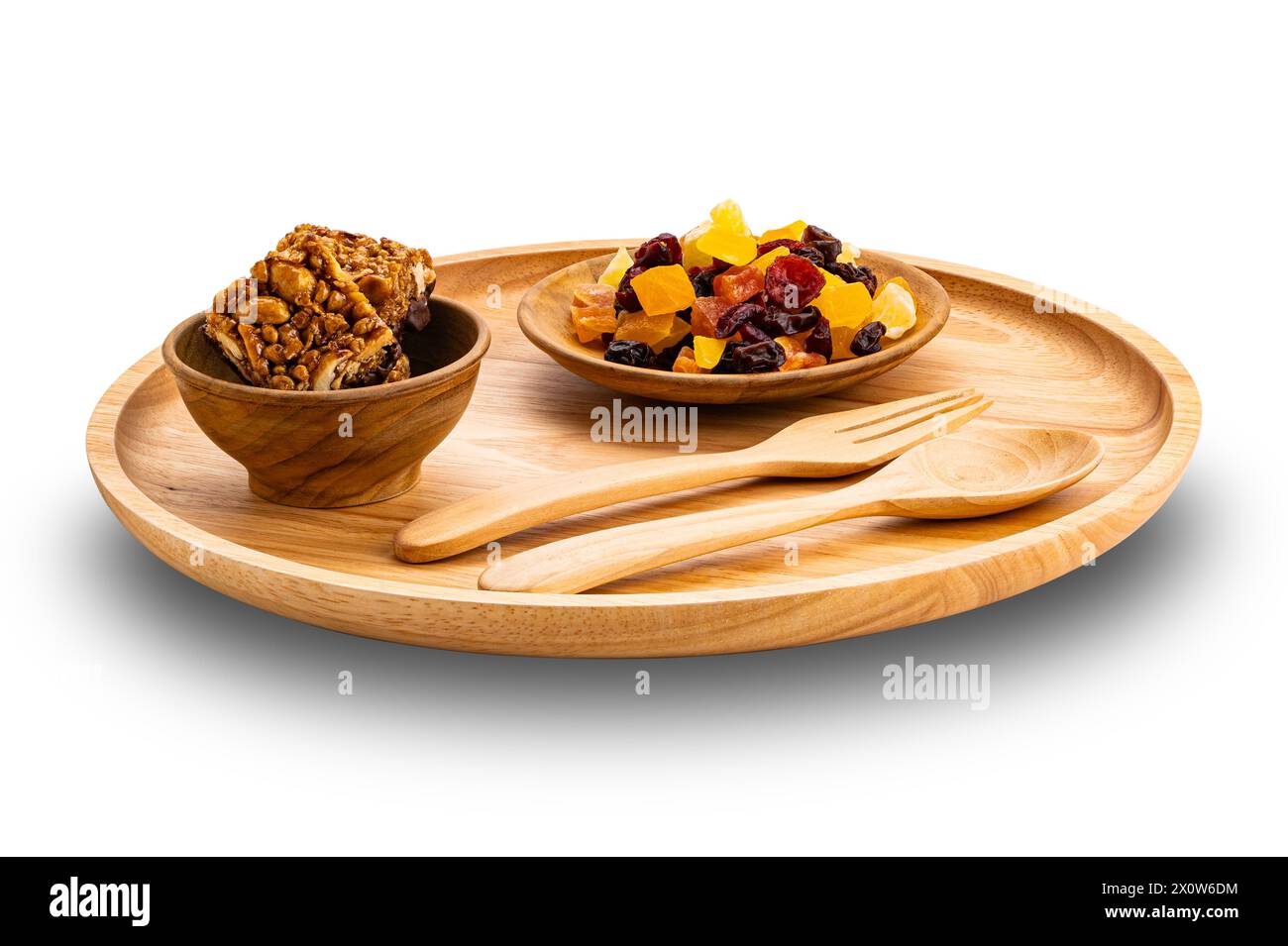Ansicht von Proteinstäben in Holzschüssel mit gemischten getrockneten tropischen Früchten in Holzschale und Holzfrosch und Löffel in Platte isoliert auf weißem Hintergrund wi Stockfoto