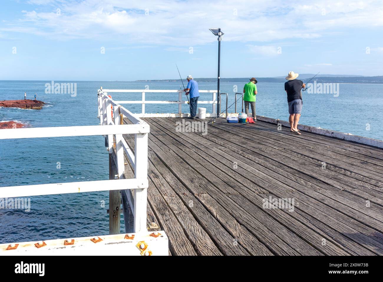 Männer fischen vor Merimbula Wharf, Merimbula, New South Wales, Australien Stockfoto