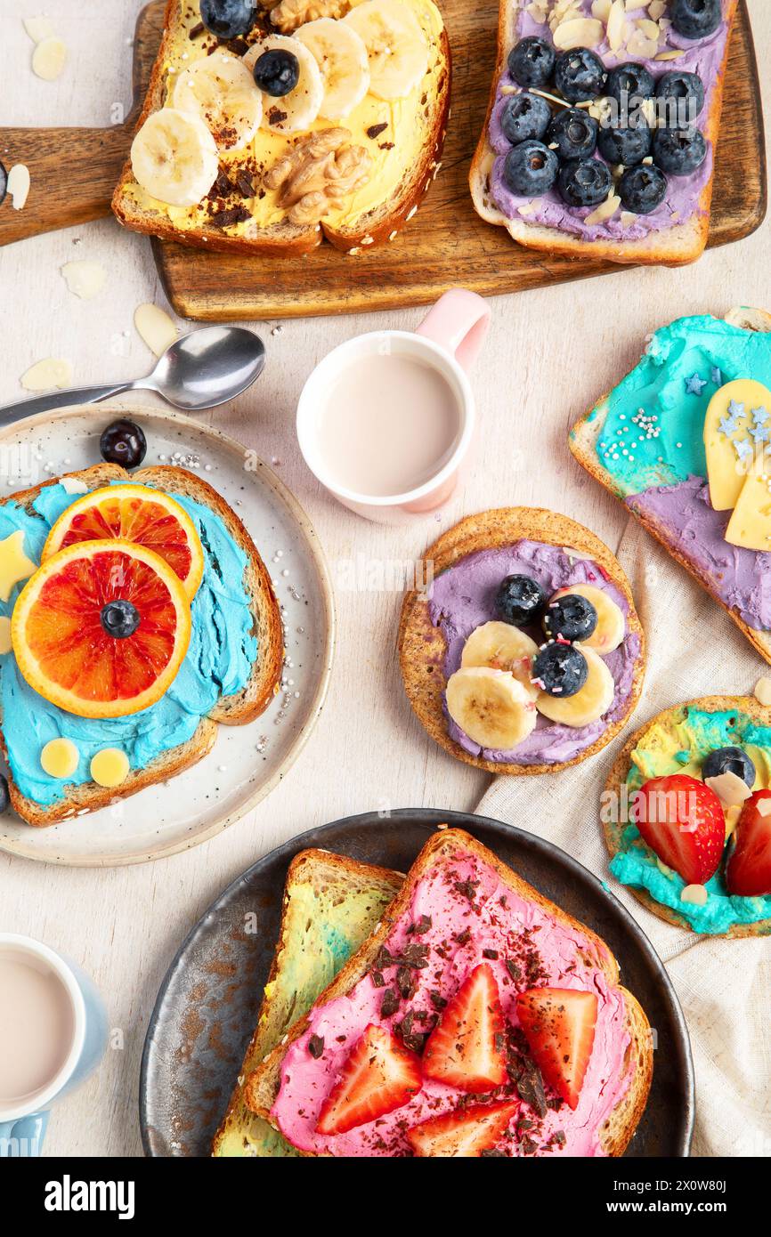 Süßes Frühstück mit einer Tasse Kakao. Toast mit Frischkäse, Banane, Erdbeeren, Heidelbeeren. Draufsicht Stockfoto