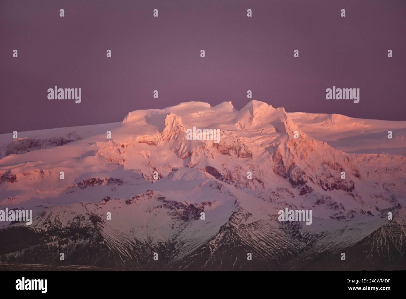 Wintersonnenaufgang über schneebedeckten Vulkangipfeln, Island Stockfoto