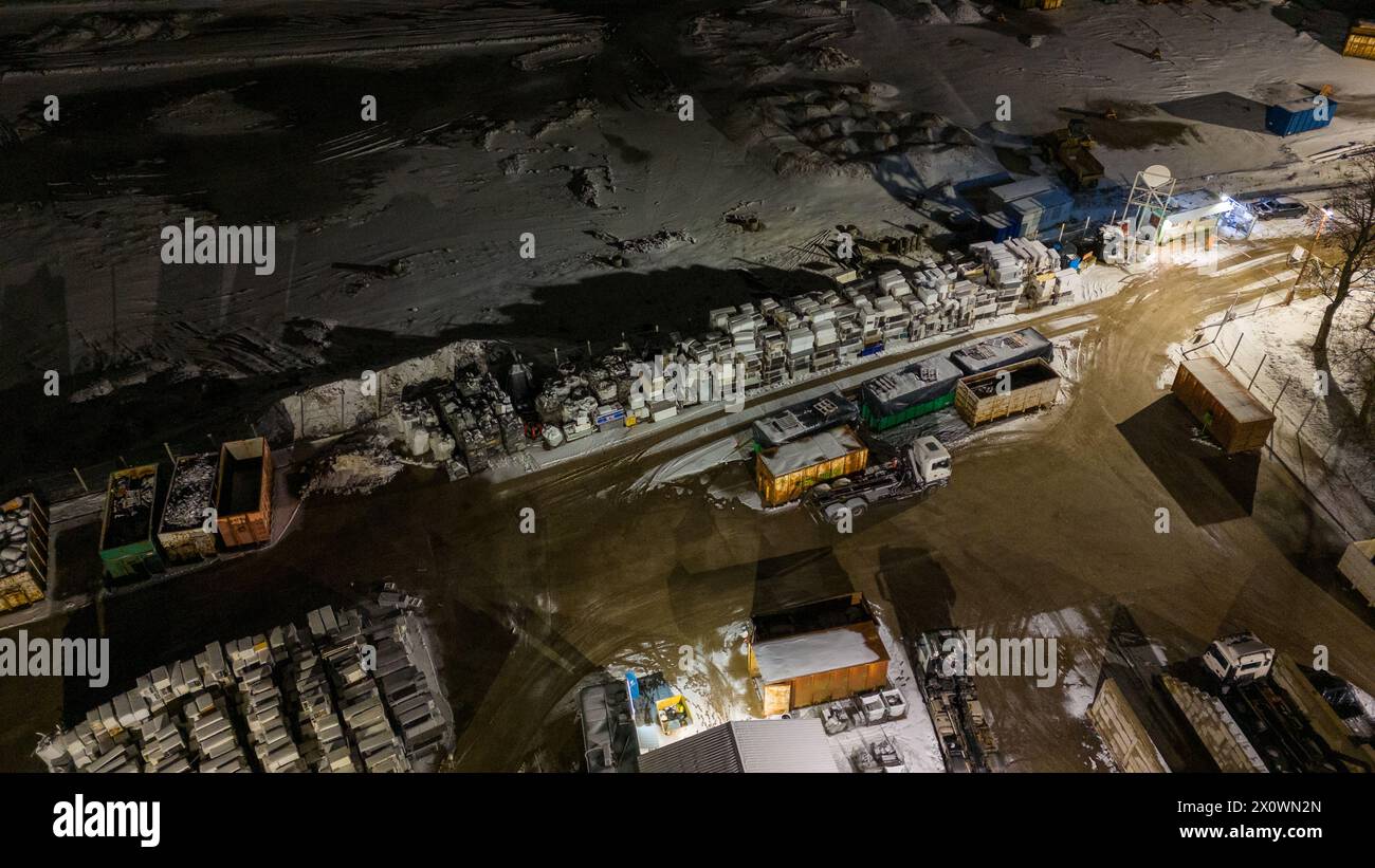 Drohnenfotografie von Metall-Recycling-Anlagen in der Nacht und Metallhaufen in der winterlichen bewölkten Nacht Stockfoto