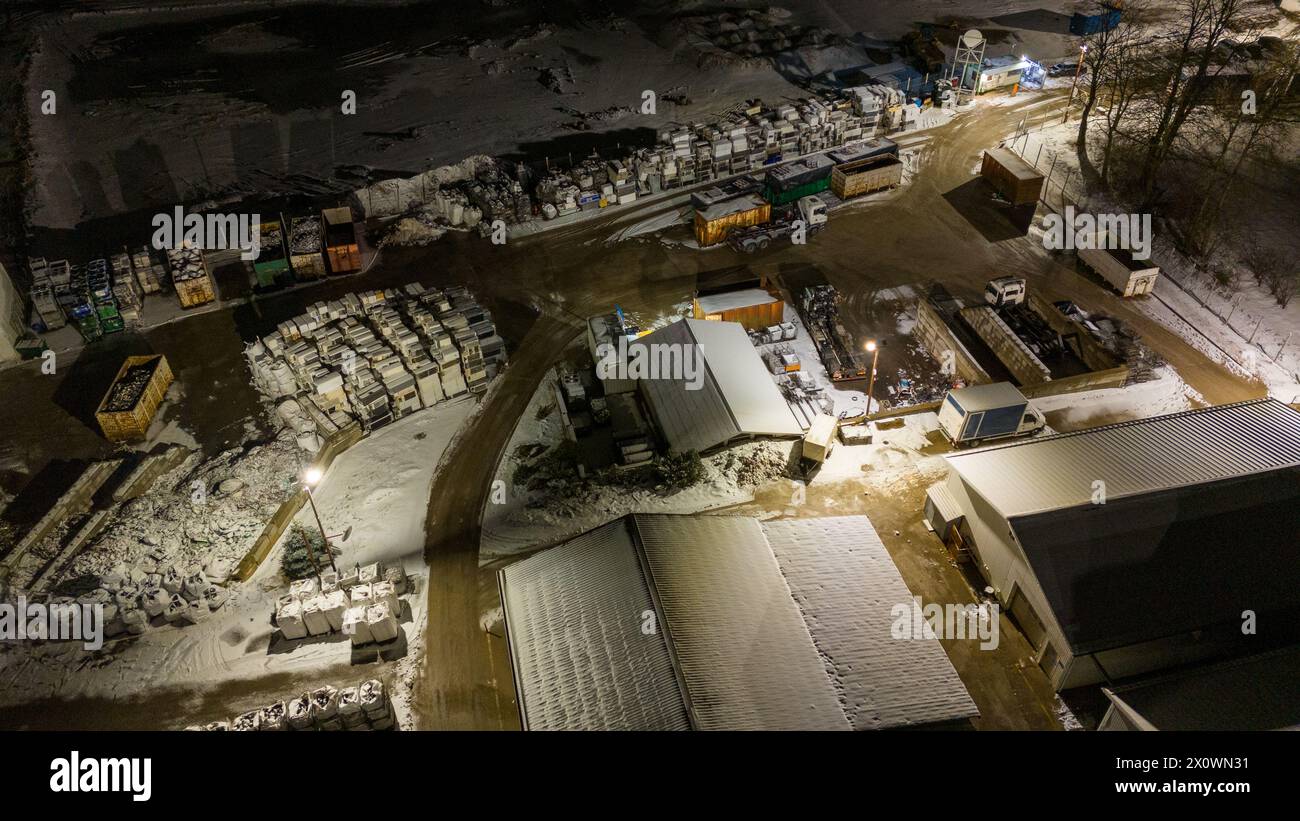 Drohnenfotografie von Metall-Recycling-Anlagen in der Nacht und Metallhaufen in der winterlichen bewölkten Nacht Stockfoto