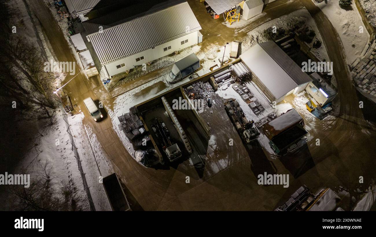 Drohnenfotografie von Metall-Recycling-Anlagen in der Nacht und Metallhaufen in der winterlichen bewölkten Nacht Stockfoto
