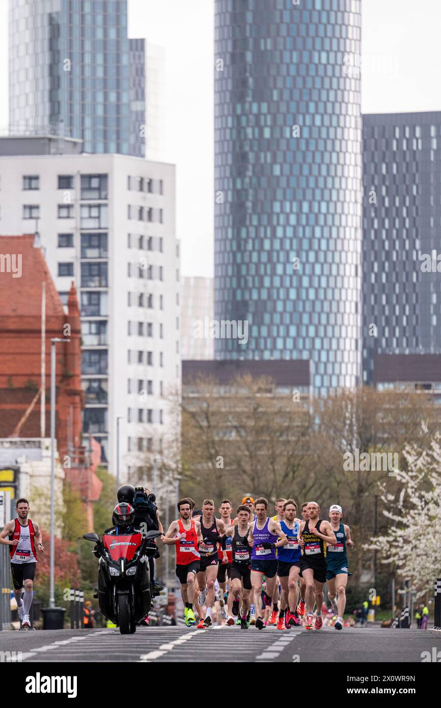 Manchester, Großbritannien. April 2024. Elite-Läufer mit Kamerarad Manchester Marathon 2024. Auf der Chester Road, kurz hinter der 1,5 km-Marke. Hochhäuser im Hinterland des Manchester Centre. Bild: Garyroberts/worldwidefeatures.com Credit: GaryRobertsphotography/Alamy Live News Stockfoto