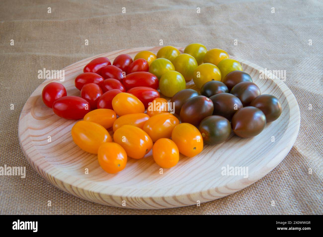 Stillleben: Cherry-Tomaten auf hölzerne Schüssel sortiert. Stockfoto