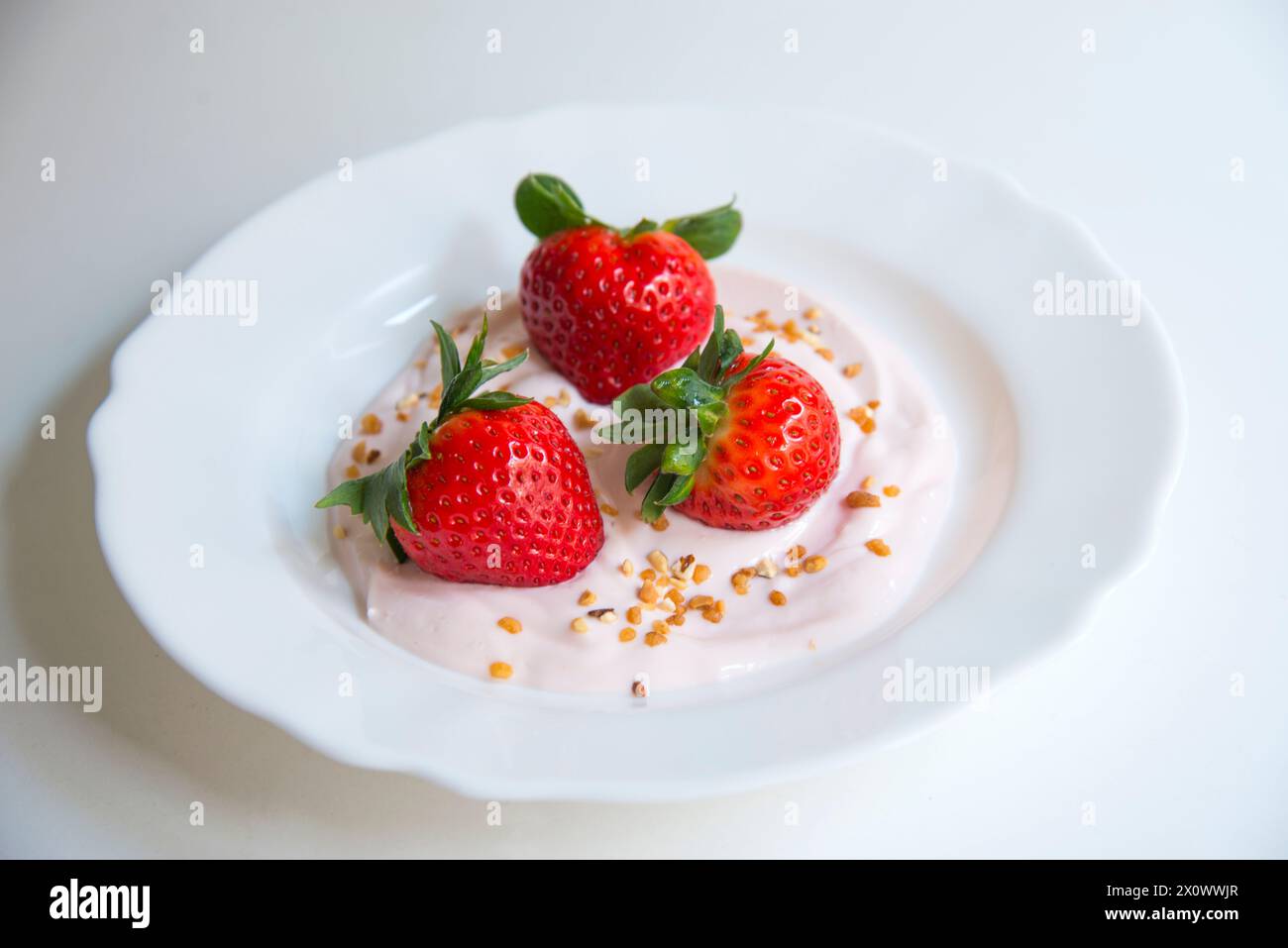 Drei Erdbeeren mit Erdbeercreme. Stockfoto