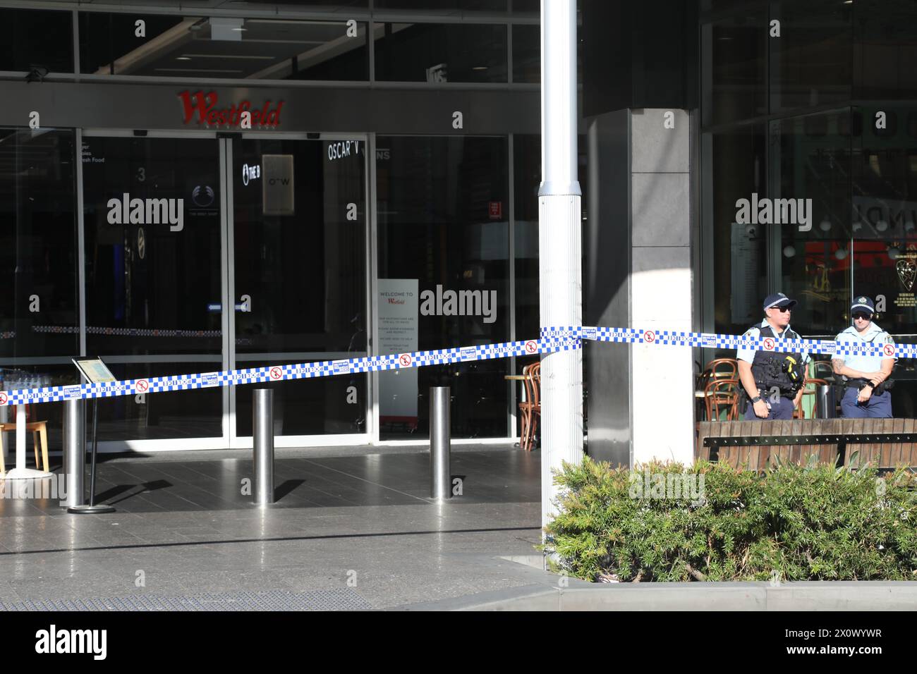 Sydney, Australien. April 2024. Der Tatort von Westfield Bondi Junction ist immer noch von der Polizei gesperrt und die Leute lassen Blumen im Einkaufszentrum gegenüber, nachdem ein geistig kranker Messerangreifer, der 40-jährige Joel Cauchi, einen Amoklauf begangen hat und 6 Menschen getötet hat. Richard Milnes/Alamy Live News Stockfoto