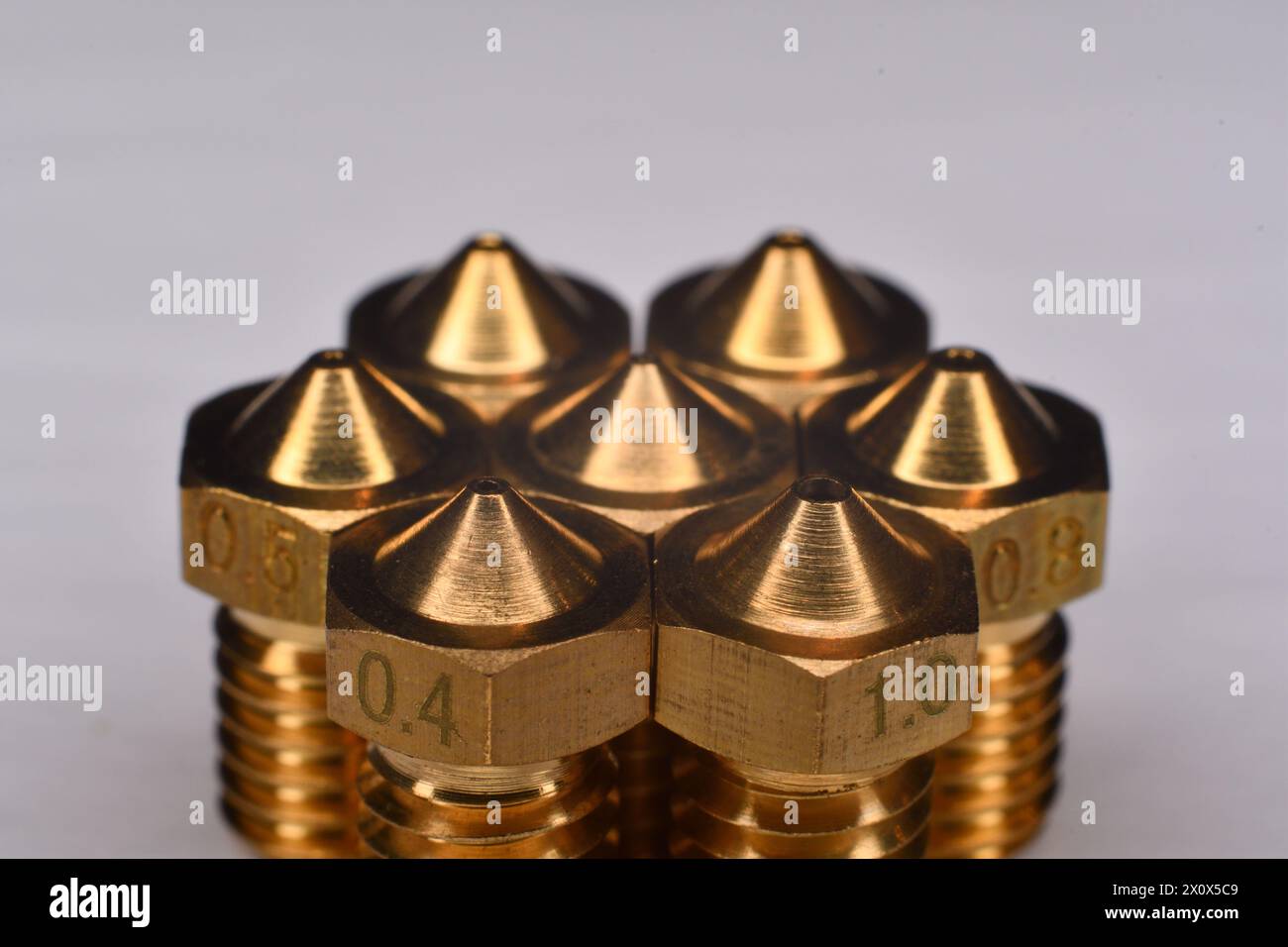 Messingdüse für 3D-Drucker. Makro mit verschiedenen Düsengrößen des Druckers. Messingdüsen mit Gewinde. Teile für 3D-Drucker Stockfoto