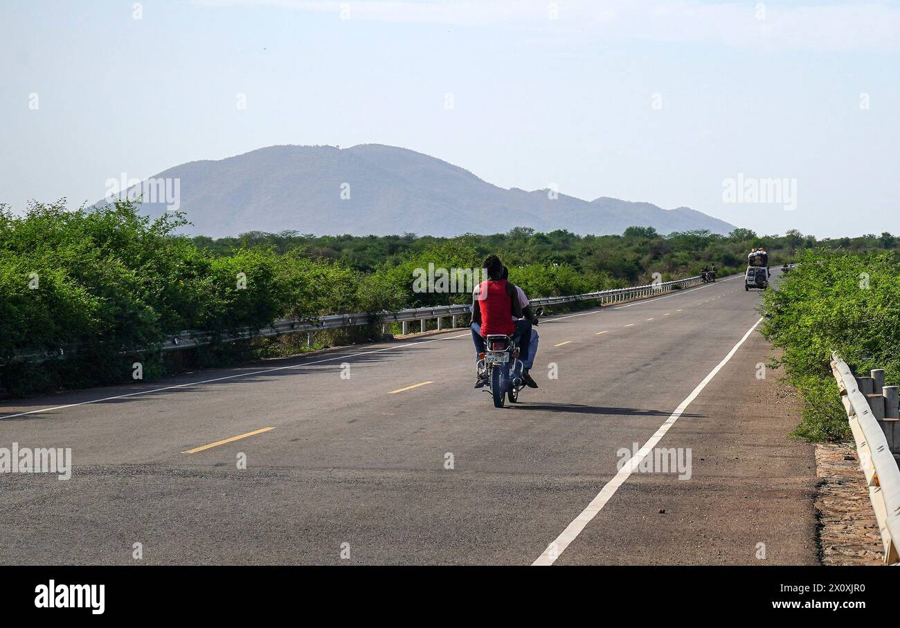 Juba, Südsudan. April 2024. Ein Fahrzeug- und Motorradrennen auf der Straße des Juba-Terekeka-Abschnitts des Juba-Rumbek Highway Project im Terekeka County, Südsudan, am 11. April 2024. Das Juba-Rumbek Highway Project, durchgeführt von der chinesischen Shandong Hi-Speed Co. Ltd (SDHS) ist gemäß dem Vertrag zwischen China und Südsudan in vier Abschnitte unterteilt. Der erste Abschnitt 63 von Juba nach Terekeka wurde fertiggestellt und im Juni 2022 für den Verkehr freigegeben, wobei im Dezember 2022 eine offizielle Zeremonie anlässlich seiner Eröffnung stattfand. Quelle: Han Xu/Xinhua/Alamy Live News Stockfoto