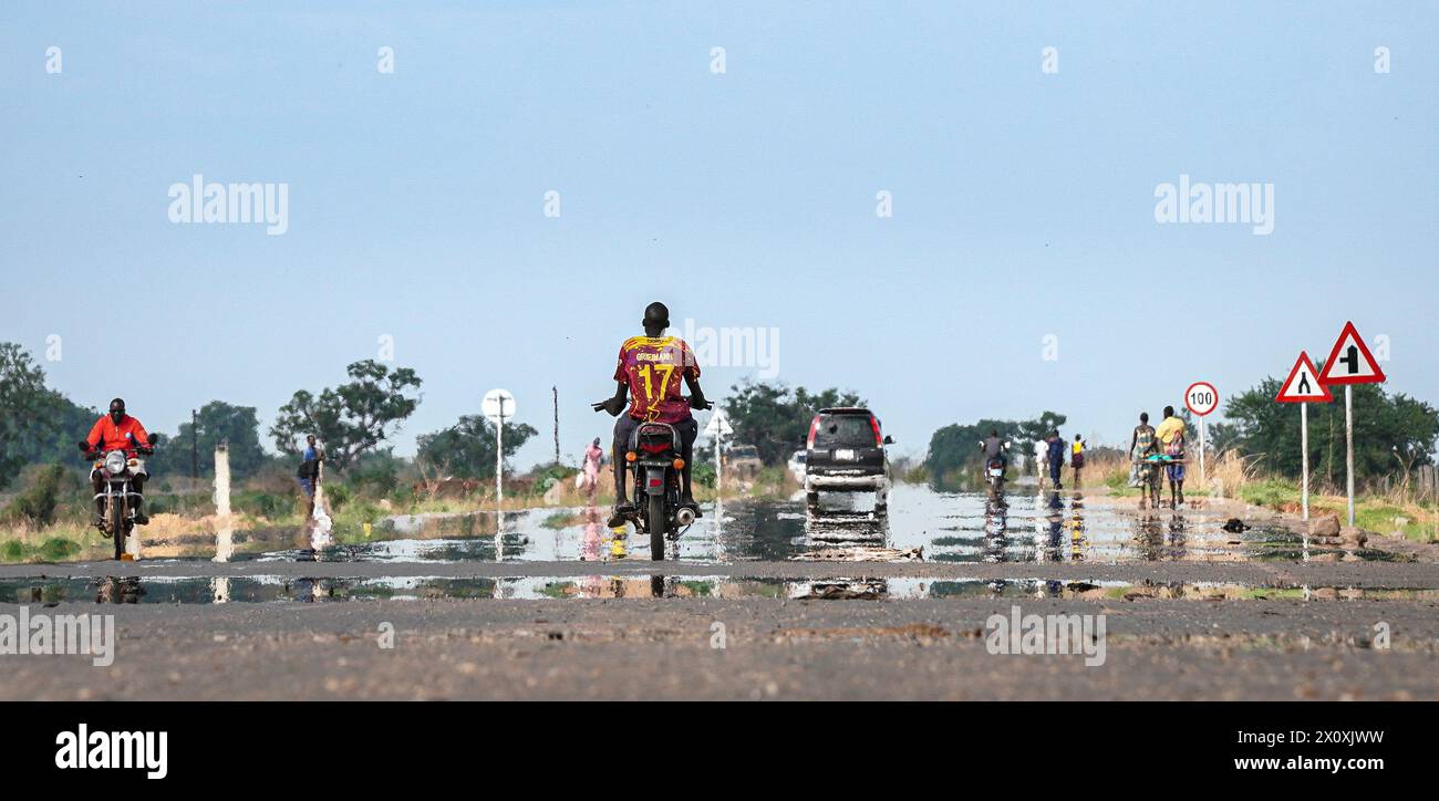 (240414) -- JUBA, 14. April 2024 (Xinhua) -- Ein Fahrzeug und Motorräder fahren am 11. April 2024 auf der Straße des Juba-Terekekeka-Abschnitts des Juba-Rumbek Highway Projektes in Terekeka County, Südsudan. Das Juba-Rumbek Highway Project, durchgeführt von der chinesischen Shandong Hi-Speed Co. Ltd (SDHS) ist gemäß dem Vertrag zwischen China und Südsudan in vier Abschnitte unterteilt. Der erste Abschnitt 63 von Juba nach Terekeka wurde fertiggestellt und im Juni 2022 für den Verkehr freigegeben, wobei im Dezember 2022 eine offizielle Zeremonie anlässlich seiner Eröffnung stattfand. (Xinhua/Han Xu) Stockfoto