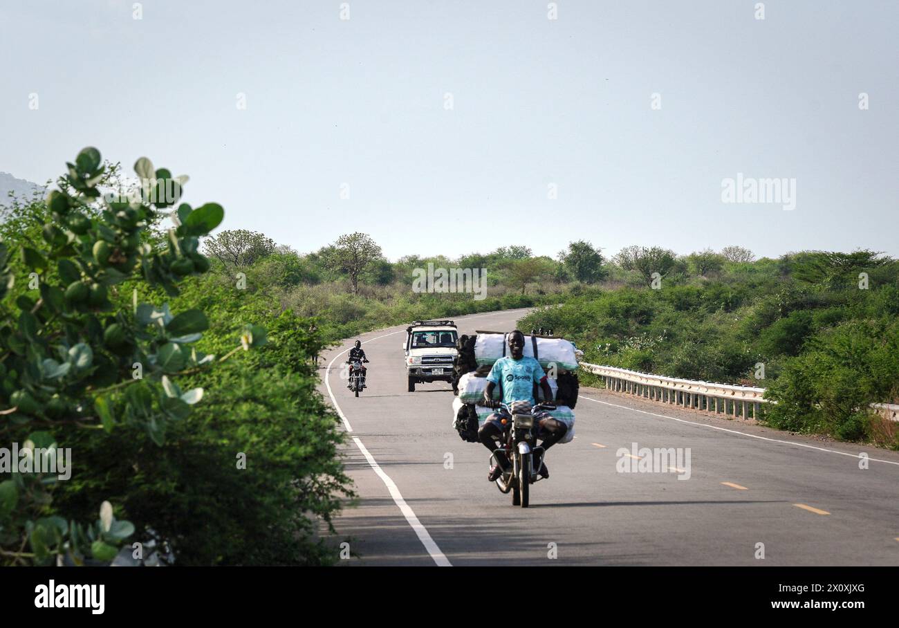 (240414) -- JUBA, 14. April 2024 (Xinhua) -- Ein Fahrzeug und Motorräder fahren am 11. April 2024 auf der Straße des Juba-Terekekeka-Abschnitts des Juba-Rumbek Highway Projektes in Terekeka County, Südsudan. Das Juba-Rumbek Highway Project, durchgeführt von der chinesischen Shandong Hi-Speed Co. Ltd (SDHS) ist gemäß dem Vertrag zwischen China und Südsudan in vier Abschnitte unterteilt. Der erste Abschnitt 63 von Juba nach Terekeka wurde fertiggestellt und im Juni 2022 für den Verkehr freigegeben, wobei im Dezember 2022 eine offizielle Zeremonie anlässlich seiner Eröffnung stattfand. (Xinhua/Han Xu) Stockfoto