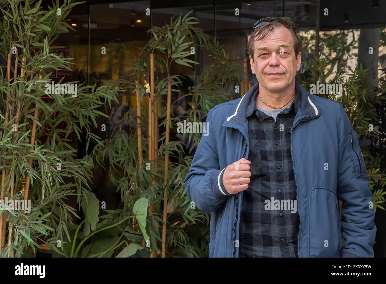 Porträt eines älteren Mannes, 50-55 Jahre alt, auf einem neutralen urbanen Hintergrund, wegblickend. Stockfoto