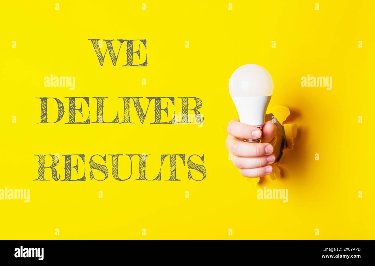 Eine Person, die eine Glühbirne mit den Worten We Deliver Results (Wir liefern Ergebnisse) hält, die unten aufgeführt sind. Konzept von Innovation und Fortschritt, da die Glühbirne oft assoziiert ist Stockfoto
